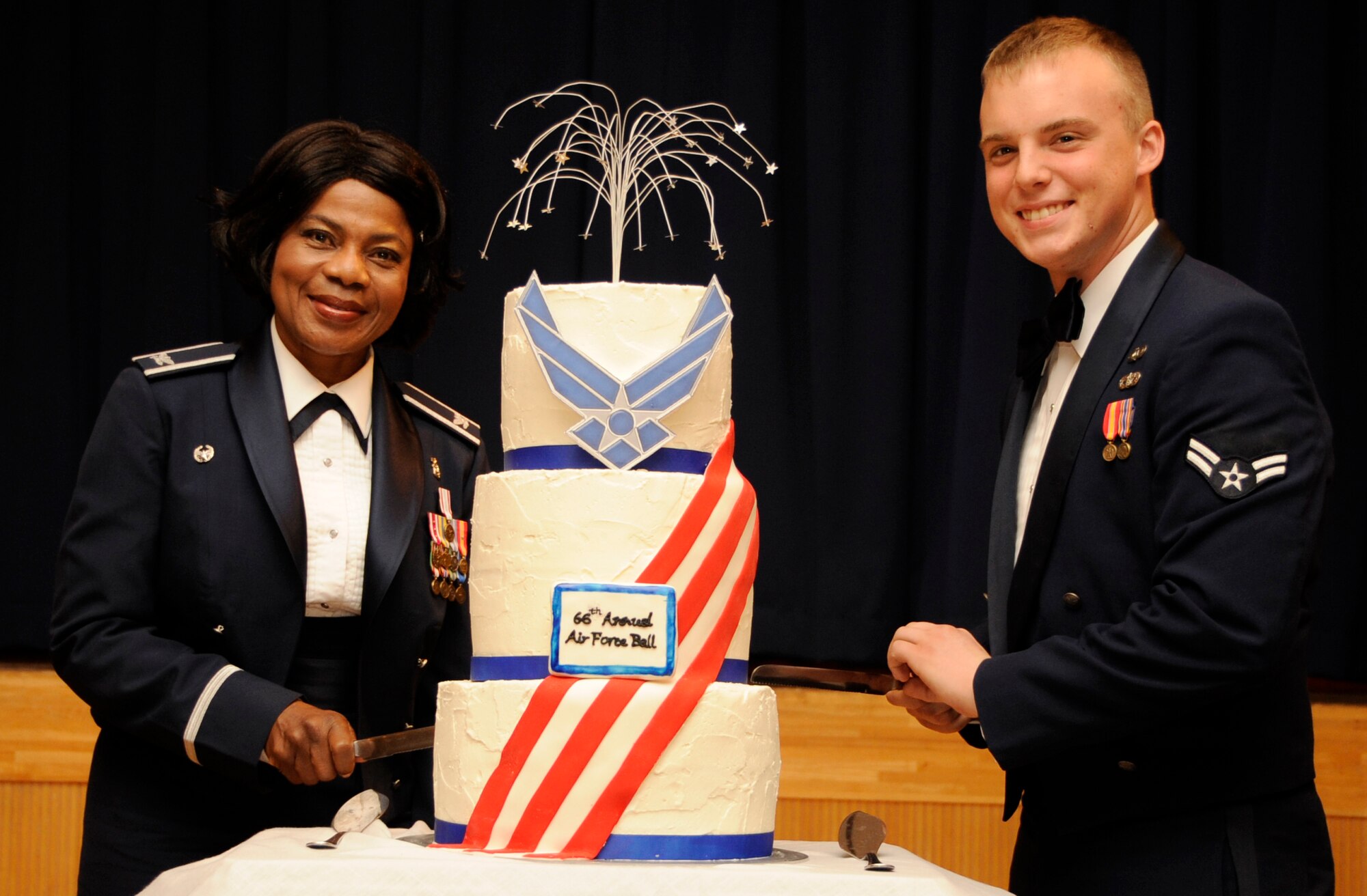 U.S. Air Force Col. Bernadette Anderson, 35th Medical Group deputy commander, left, and Airman 1st Class Zachary Clement, 35th Civil Engineer Squadron emergency management apprentice, cut the cake during the 66th Annual U.S. Air Force Ball at Misawa Air Base, Japan, Sept. 21, 2013. It is tradition for the “oldest” Airman to cut the cake with the “youngest” Airman. (U.S. Air Force photo by Airman 1st Class Kaleb Snay)