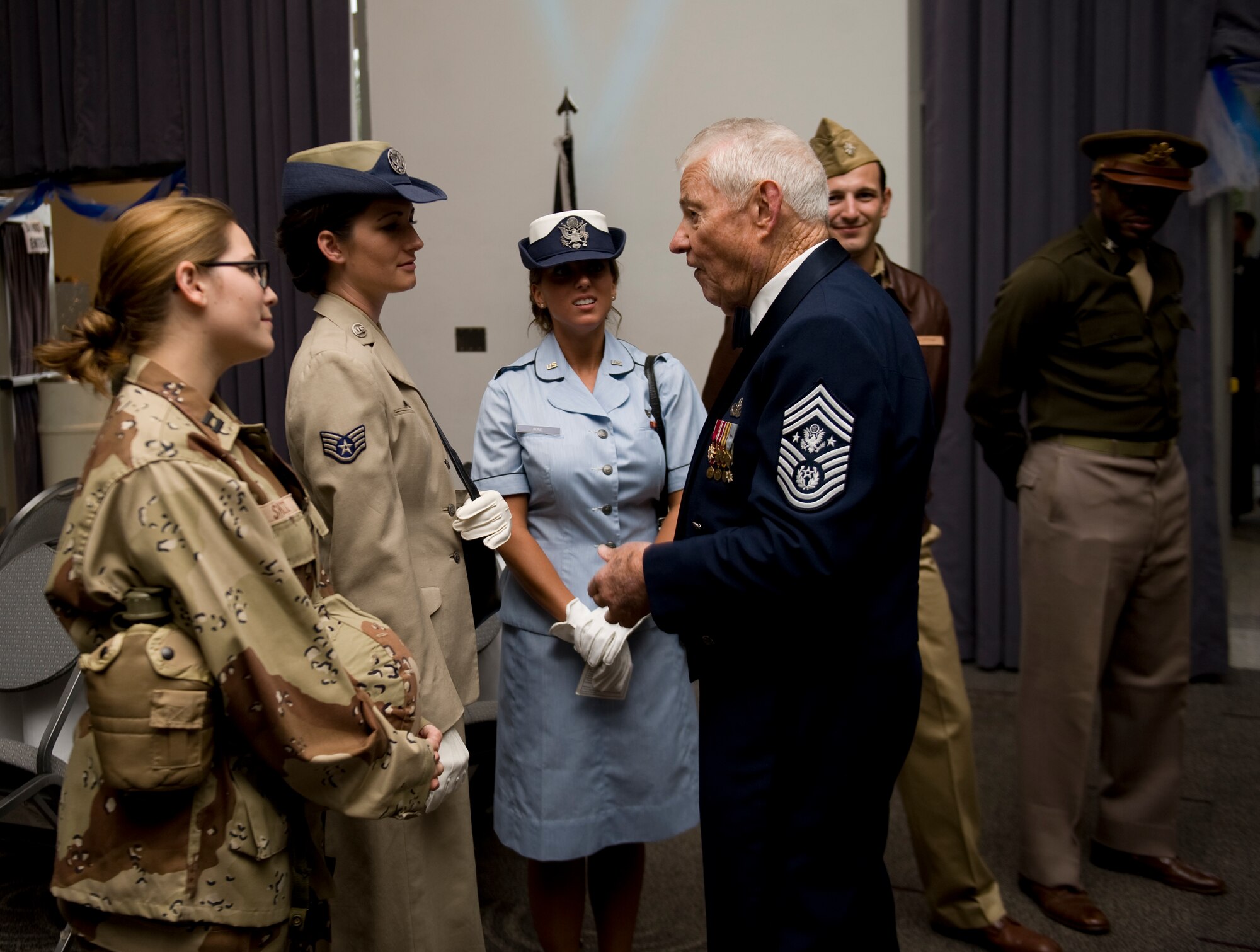 Retired Chief Master Sgt. of the Air Force Robert Gaylor speaks to several Airmen during an Air Force ball Sept. 20, 2013, at the Civic Center, in Abilene, Texas. During the ball, Airmen displayed Air Force uniforms from different time periods throughout Air Force history as part of a skit in commemoration of the Air Force’s 66th birthday. (U.S. Air Force photo by Airman 1st Class Alexander Guerrero/Released)