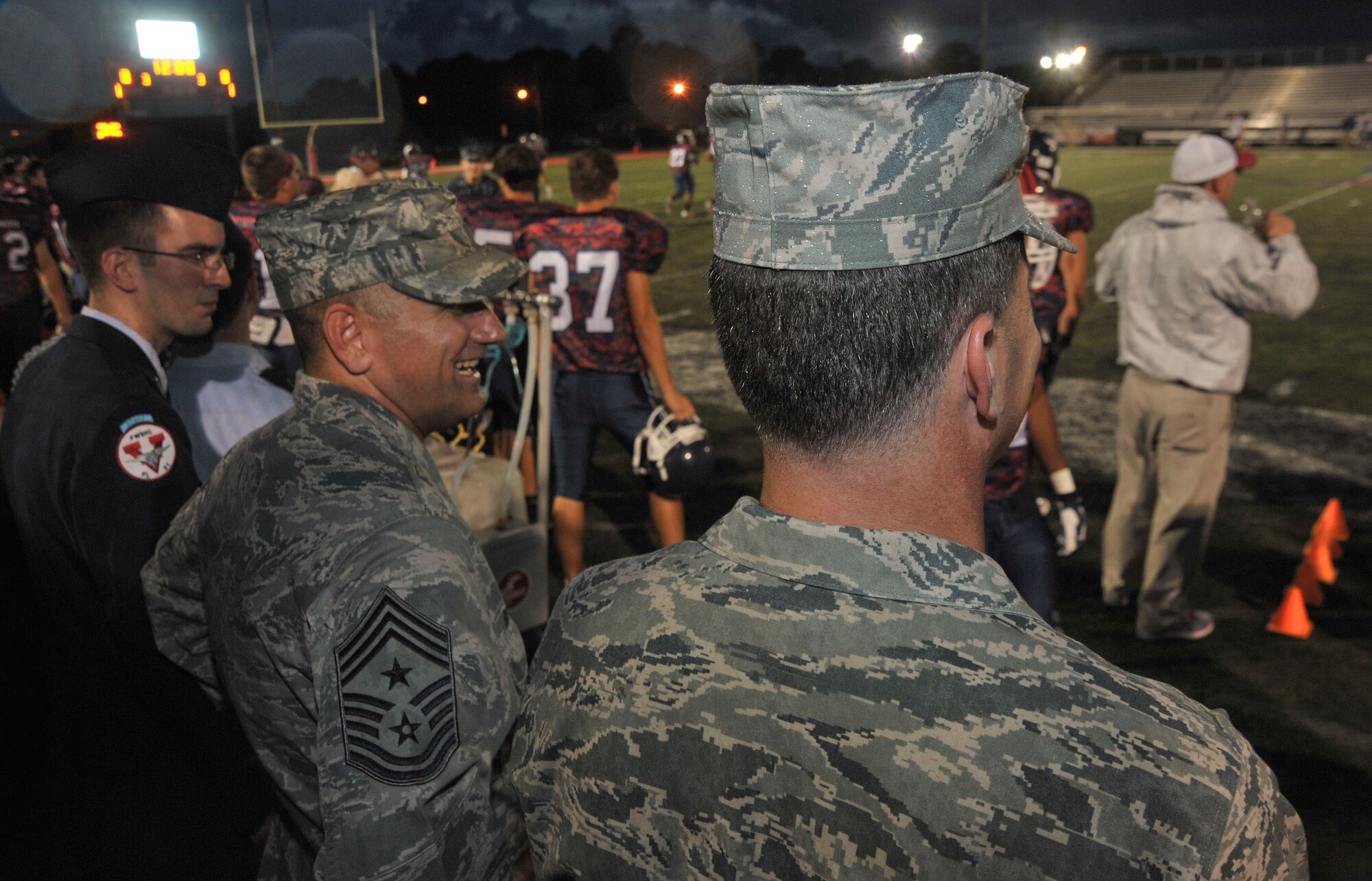 Chief Master Sgt. John Barnhouse, 505th Combat Training Squadron command chief, and Col. Daniel Orcutt, 505th CTS commander, watch a high school football game in Fort Walton Beach, Fla., Sept. 20, 2013. Barnhouse and Orcutt were invited to perform the coin toss at the beginning of the game. (U.S. Air Force photo/Airman 1st Class Andrea Posey)