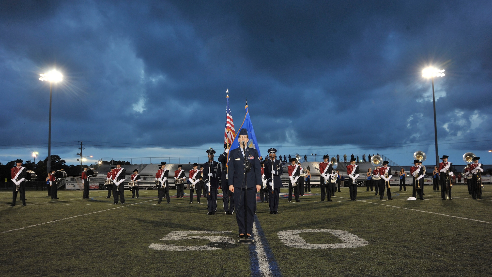 Staff Sgt. Jennifer Santillan, 1st Special Operations Force Support Squadron food service craftsman, sings the National Anthem prior to a high school football game in Fort Walton Beach, Fla., Sept. 20, 2013. Santillan and Hurlburt Field’s Honor Guard performed with Fort Walton Beach High School's band and color guard. (U.S. Air Force photo/Airman 1st Class Andrea Posey)