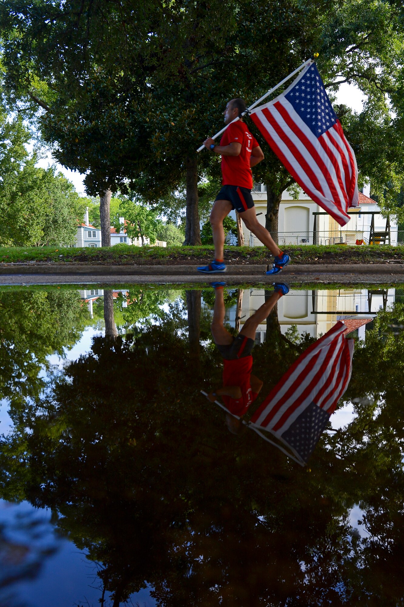 Mike Kuhr from Shreveport, La., runs with the American flag during the Barksdale Half Marathon on Barksdale Air Force Base, La., Sept. 21, 2013. Several base and community residents ran with American flags, an Air Force flag and even their Airman Leadership School flags the entire race. (U.S. Air Force photo/Senior Airman Micaiah Anthony)
