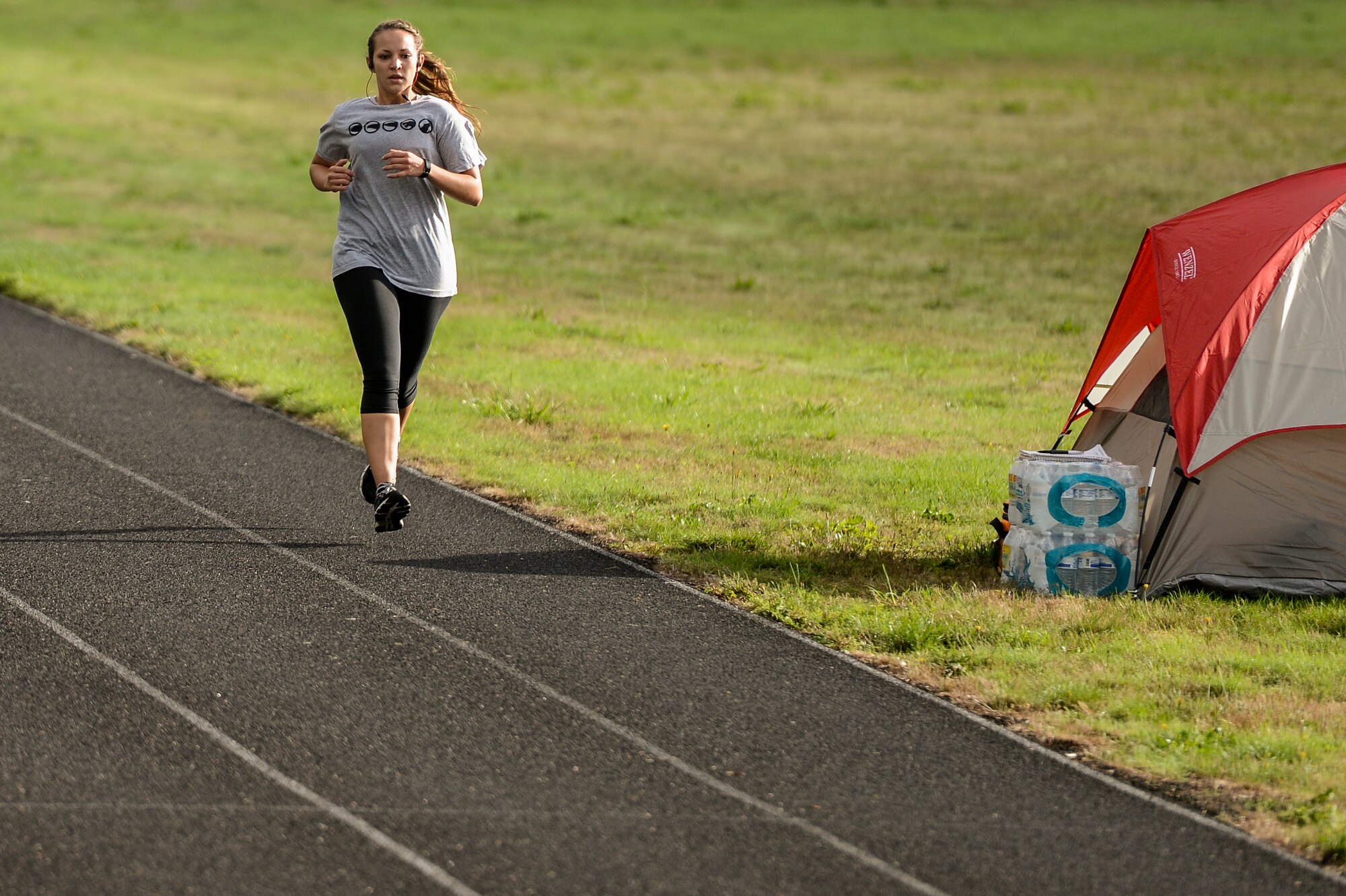 Senior Airman Skye Vicchio, 627th Logistics Readiness Squadron war reserve materiel manager, runs past a tent, Sept. 18, 2013, during the 24-hour POW/MIA run at Joint Base Lewis-McChord, Wash. For the event, many members pitched tents in the infield of the running track to rest and prepare for their turn to run. (U.S. Air Force photo/Tech. Sgt. Sean Tobin)
