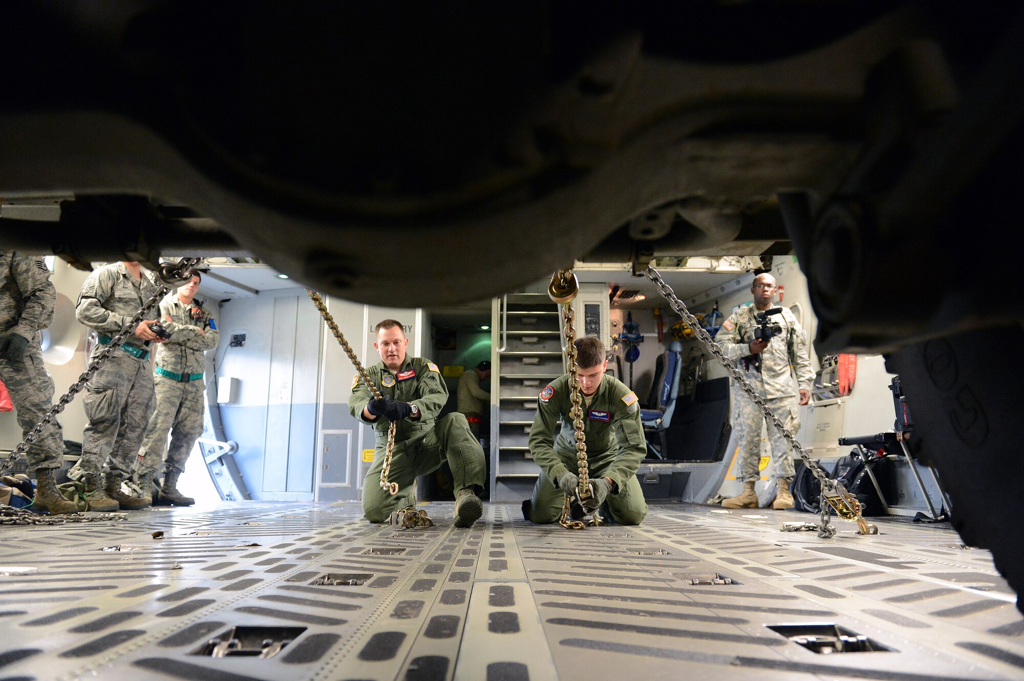 Master Sgt. Justin Kenley, 62nd Operations Support Squadron wing training flight superintendent (left) and Airman 1st Class Shaun Chapman, 4th Airlift Squadron loadmaster chain down an M142 High Mobility Artillery Rocket System on a C-17 Globemaster III aircraft, Sept. 17, 2013, at Joint Base Lewis-McChord, Wash., during a HIMARS Rapid Infiltration (HI-RAIN) exercise. The exercise was an opportunity for both services to get hands-on experience with rapid deployment using joint assets. (U.S. Air Force photo/Airman 1st Class Jacob Jimenez) 