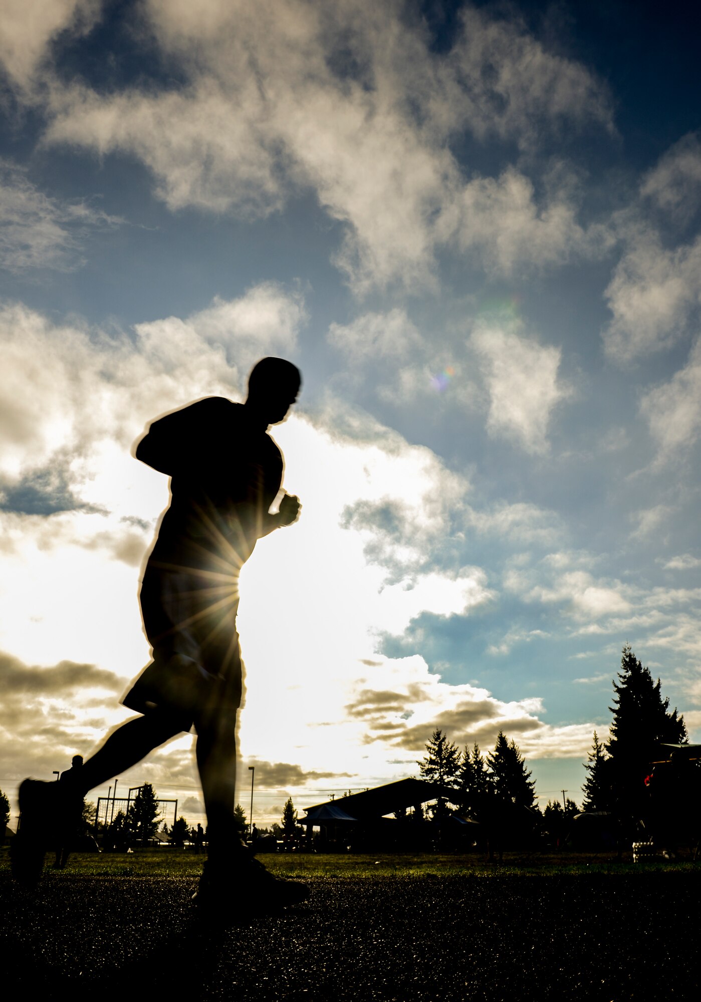 Staff Sgt. Christopher Mott, 627th Logistics Readiness Squadron supply technician, is silhouetted in the early morning sunlight, Sept. 18, 2013, at the McChord Field running track at Joint Base Lewis-McChord, Wash. Mott was one of more than 100 McChord Airmen who participated in the 24-hour POW/MIA memorial run. (U.S. Air Force photo/Tech. Sgt. Sean Tobin)