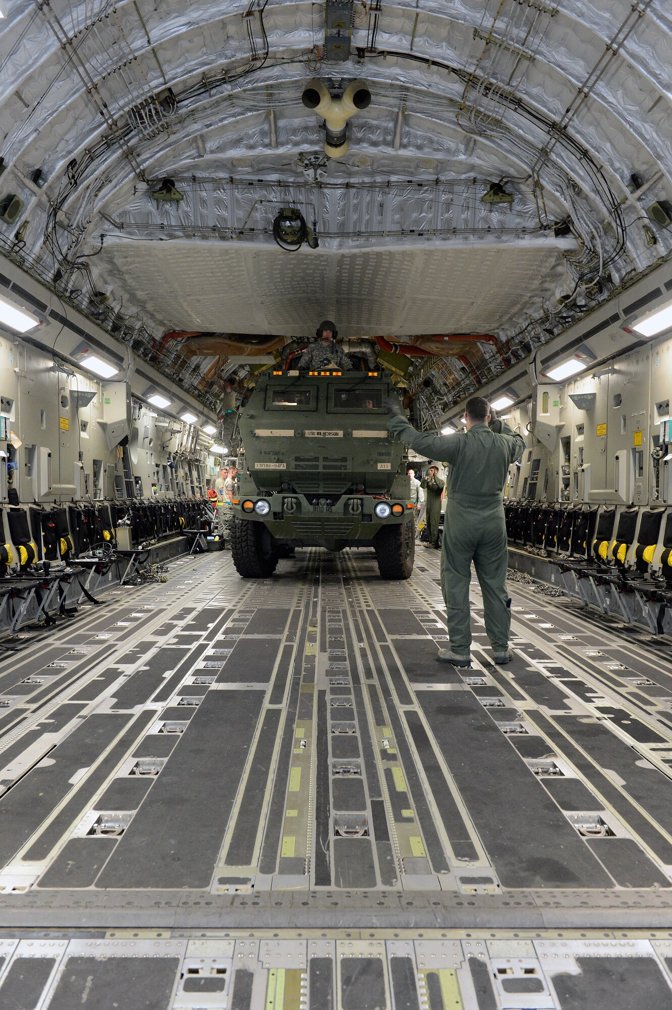 Tech. Sgt. Josh Piper, 4th Airlift Squadron instructor loadmaster marshals an M142 High Mobility Artillery Rocket System launcher into position on a C-17 Globemaster III aircraft, Sept. 17, 2013, at Joint Base Lewis-McChord, Wash. Piper was responsible for ensuring HIMARS were properly situated so that the aircraft would maintain the correct center of gravity throughout the flight.(U.S. Air Force photo/Airman 1st Class Jacob Jimenez) 