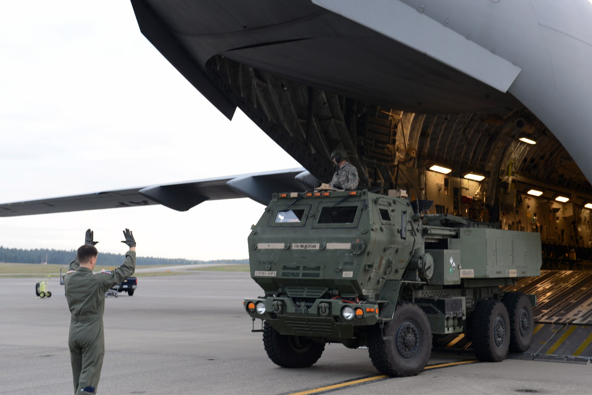 Airman 1st Class Shaun Chapman, 4th Airlift Squadron loadmaster guides Staff Sgt. Zachery Wilkerson, M142 High Mobility Artillery Rocket System chief, Alpha Battery, 1st battalion, HIMARs, 94th Field Artillery Regiment, 17th Fires Brigade, onto a C-17 Globemaster III aircraft, during a HIMARS Rapid Infiltration (HI-RAIN) exercise, Sept. 17, 2013, at Joint Base Lewis-McChord, Wash. The exercise was an opportunity for both services to get hands-on experience with rapid deployment using joint assets. (U.S. Air Force photo/Airman 1st Class Jacob Jimenez)