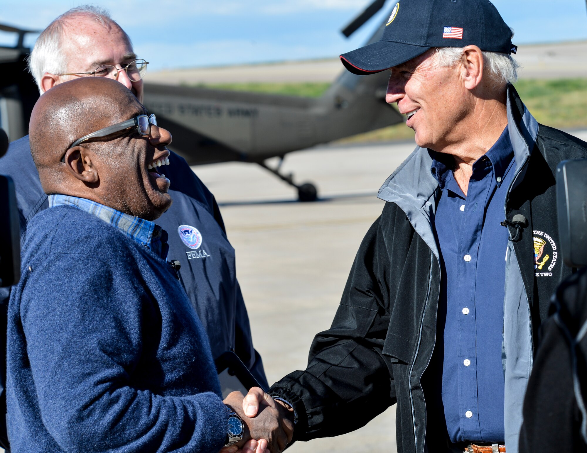 Al Roker, NBC weather forecaster, left, laughs with Vice President Joe Biden Sept. 23, 2013, at Buckley Air Force Base, Colo. Biden and various new affiliates visited Colorado to view the damage and survey recovery efforts after the flooding that killed at least eight people and ravaged at least 14 counties. (U.S. Air Force photo by Airman 1st Class Riley Johnson/Released)