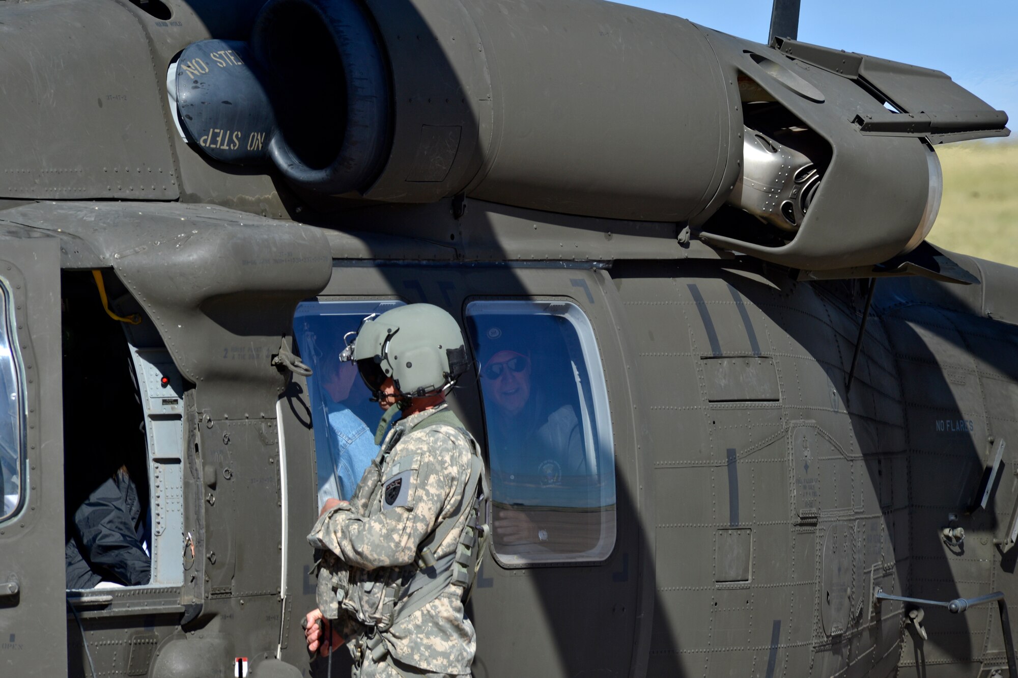 Vice President Joe Biden, right, peers out the window of a Colorado Army National Guard UH-60 Black Hawk as the crew chief opens the door Sept. 23, 2013, at Buckley Air Force Base, Colo. Biden visited Colorado to view the damage and survey recovery efforts after the flooding that killed at least eight people and ravaged at least 14 counties. (U.S. Air Force photo by Airman 1st Class Riley Johnson/Released)