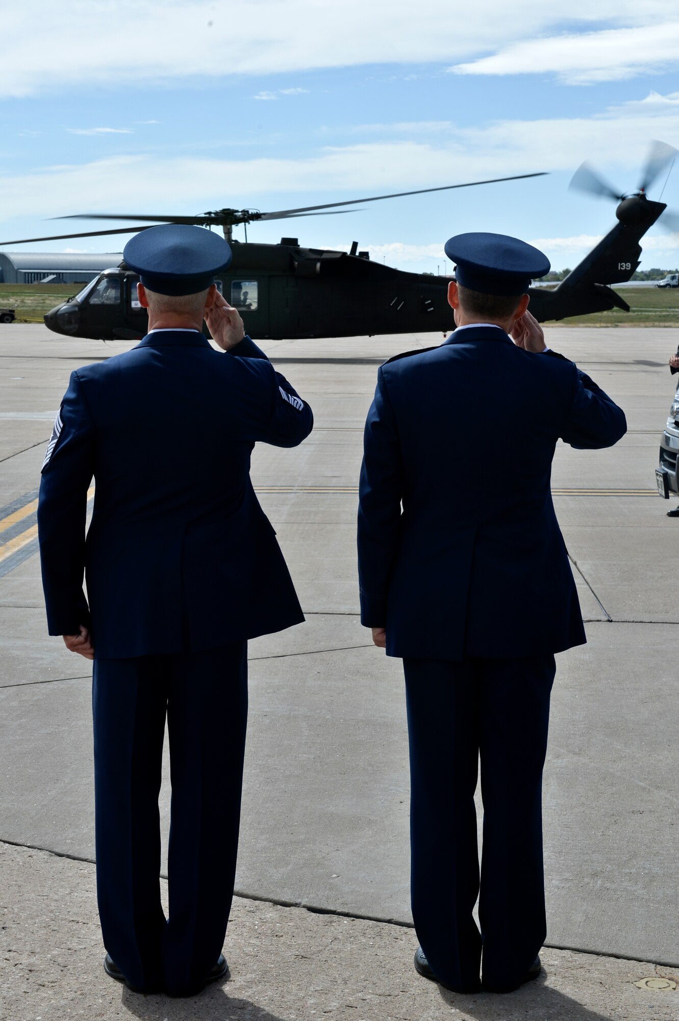 Chief Master Sgt. Craig S. Hall, 460th Space Wing command chief, left, and Col. Dan Wright, 460th SW commander, salute Vice President Joe Biden as he departs on a Colorado Army National UH-60 Black Hawk Sept. 23, 2013, at Buckley Air Force Base, Colo. Biden visited Colorado to view the damage and survey recovery efforts after the flooding that killed at least eight people and ravaged at least 14 counties.  (U.S. Air Force photo by Airman 1st Class Riley Johnson/Released)