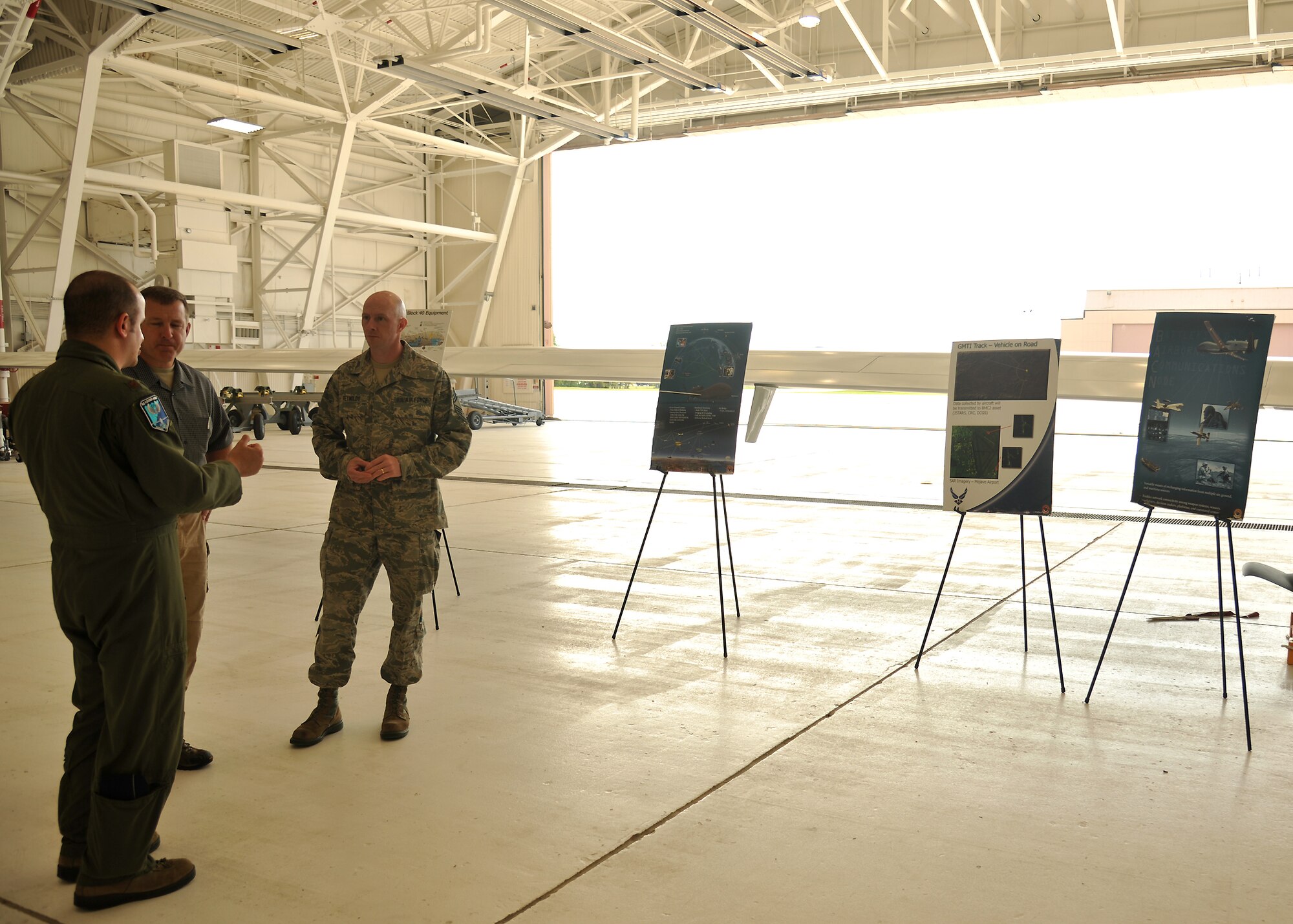 Maj. Donald Hicks, Commander's Action Group director (left), speaks to Brendan Smith, anti-terrorism officer, and Chief Master Sgt. Wayne Reynolds, air traffic manager, from Volk Field Air National Guard Base, Wis, Sept. 19, 2013, on Grand Forks Air Force Base, N.D. The purpose of their visit was to assist the Air National Guard at Volk Field in building their Unmanned Aircraft Systems program, while also strengthening the possibility of using their airfield in the future in case of any emergency or weather diverts. (U.S. Air Force photo/Senior Airman Xavier Navarro)