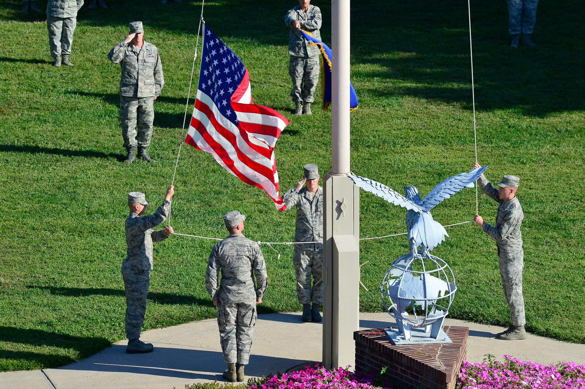 An honor guard contingent lowers the flag during a retreat ceremony Sept. 20, 2013, at the wing headquarters building on Dover Air Force Base, Del. The retreat ceremony was held to close the honoring of prisoner of war/missing in action Remembrance Day. (U.S. Air Force photo/David Tucker)