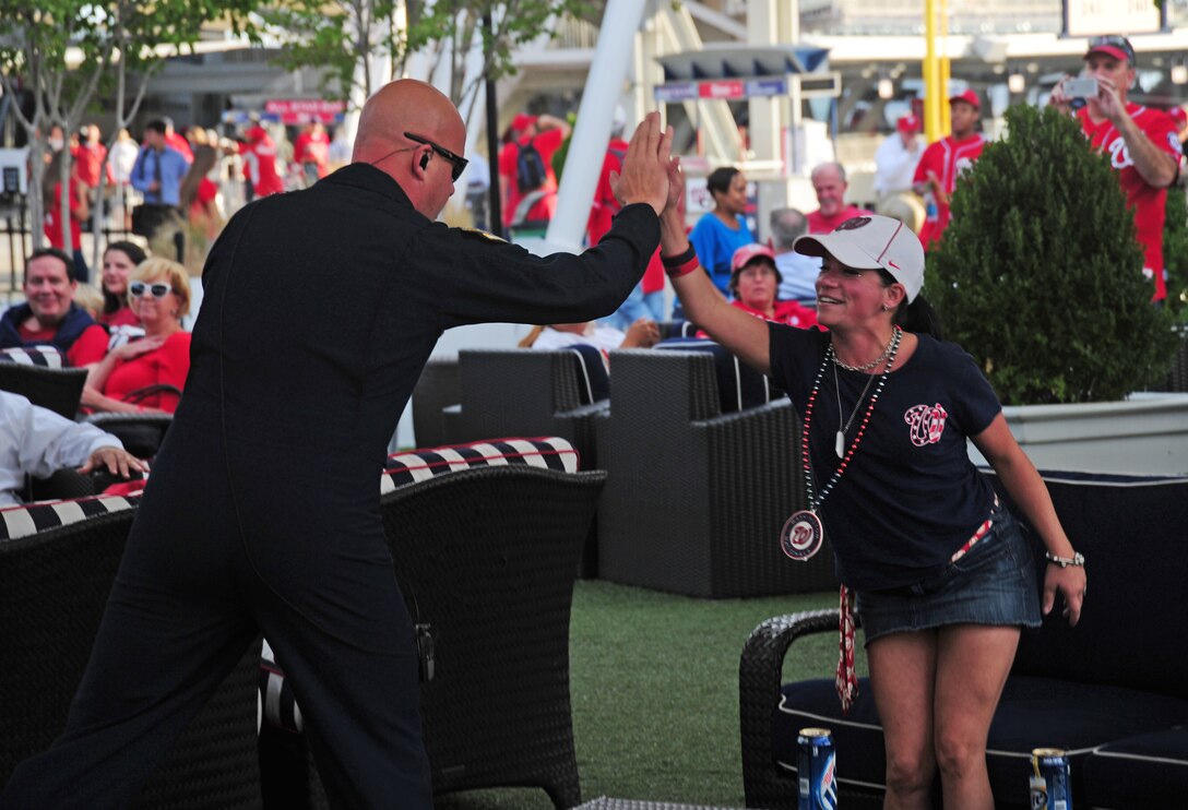 Master Sgt. Ryan Carson, Max Impact vocalist, high-fives a fan during a performance at Nationals Park in Washington, D.C., Sept. 19, 2013. Airmen from the National Capitol Region participated in various pre-game events and ceremonies in honor of Air Force Night. (U.S. Air Force photo/Airman 1st Class Erin O’Shea) 