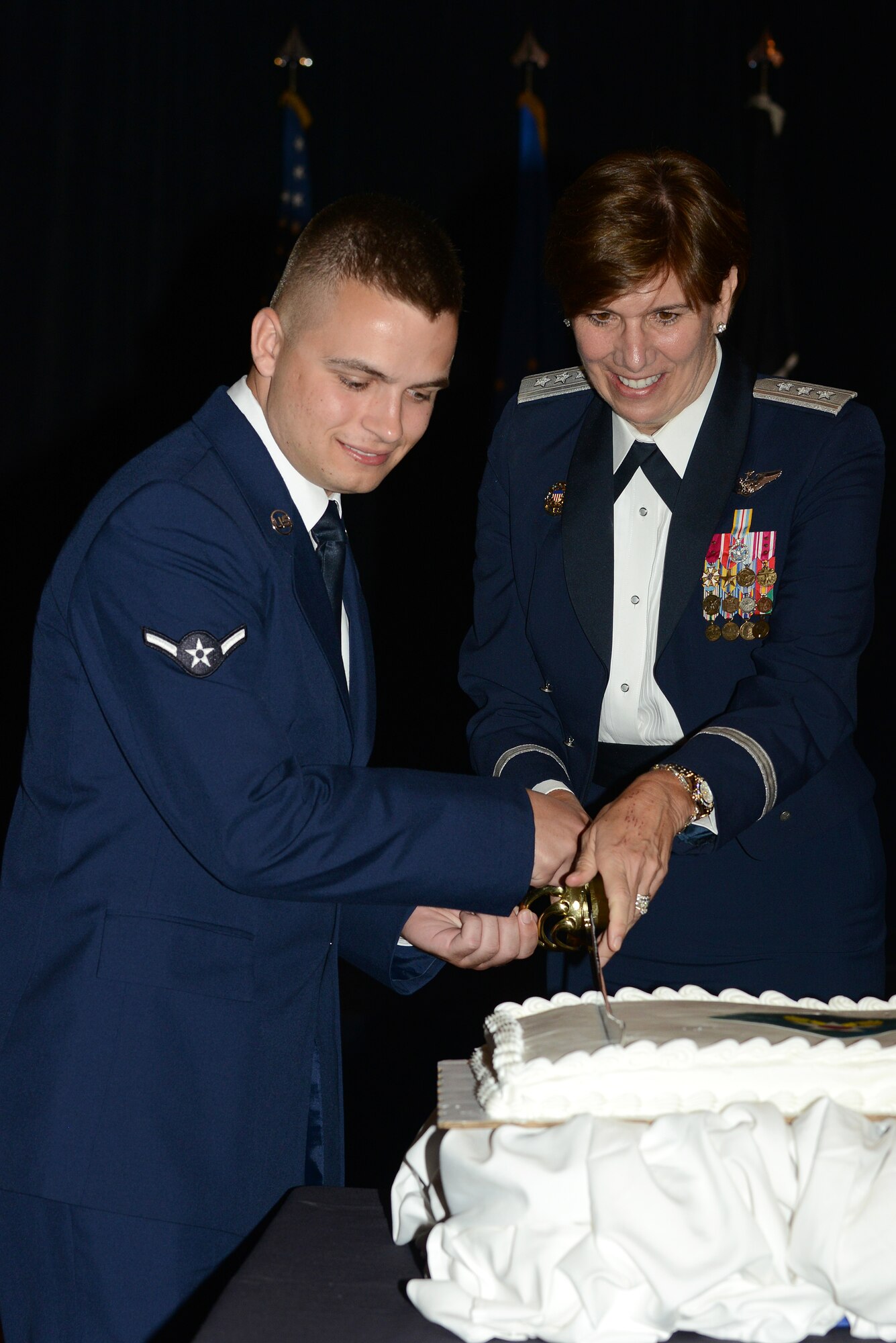 U.S. Air Force Airman Timothy Shane, a systems technician, and Lt. Gen. Lori J. Robinson, Air Combat Command vice commander, cut the Langley Air Force Ball cake in Newport News, Va., Sept. 21, 2013. Traditionally, the highest and lowest ranking attendees cut the cake. Robinson was also this year's guest speaker and discussed the accomplishments of today's Airmen. (U.S. Air Force photo by Airman 1st Class Kimberly Nagle/Released)