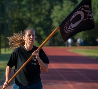 Tech. Sgt. Kristen Dierkhising, 315th Airlift Wing recruiter, runs with the POW-MIA flag during the POW/MIA Run Sept. 20, 2013, at Joint Base Charleston – Air Base, S.C. Different units from the joint base carried the flag in 30-minute increments from 3:30 p.m. Sept. 19 to 3:30 p.m. Sept. 20 in honor of all POWs and MIAs. Over 660 runners participated in the vigil and logged nearly 2,000 miles. (U.S. Air Force photo/ Airman 1st Class Chacarra Neal)