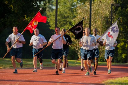 Airmen are seen running during the POW/MIA Run Sept. 20, 2013, at Joint Base Charleston – Air Base, S.C. Different units from the joint base carried the flag in 30-minute increments from 3:30 p.m. Sept. 19 to 3:30 p.m. Sept. 20 in honor of all POWs and MIAs. Over 660 runners participated in the vigil and logged nearly 2,000 miles. (U.S. Air Force photo/ Airman 1st Class Chacarra Neal)