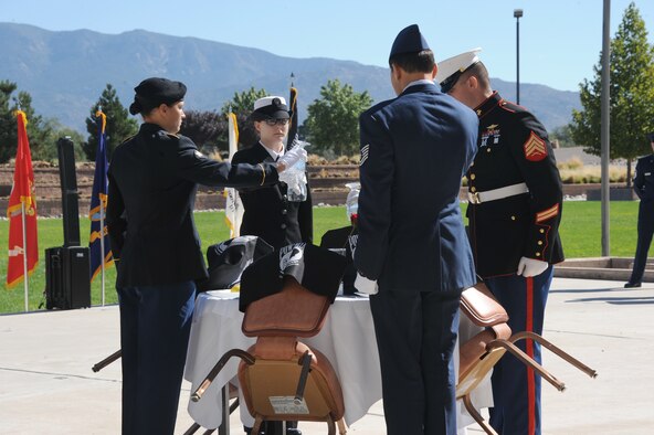 Members of the four U.S. military services create a "missing man table" at the POW/MIA Recognition Day ceremony Sept. 20 at the New Mexico Veteran's Memorial Park. The table is a place of honor serving as a focal point of ceremonial remembrance. (Photo by Dennis Carlson)