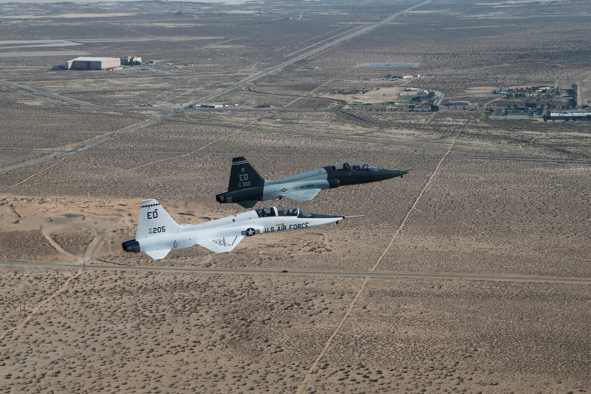 A T-38 A-model (white) and T-38 C-model are flown in formation one last time at Edwards AFB Sept.19 prior to the last two A models departing Edwards after nearly 40 years of service. (U.S. Air Force photo by Bobbi Zapka)