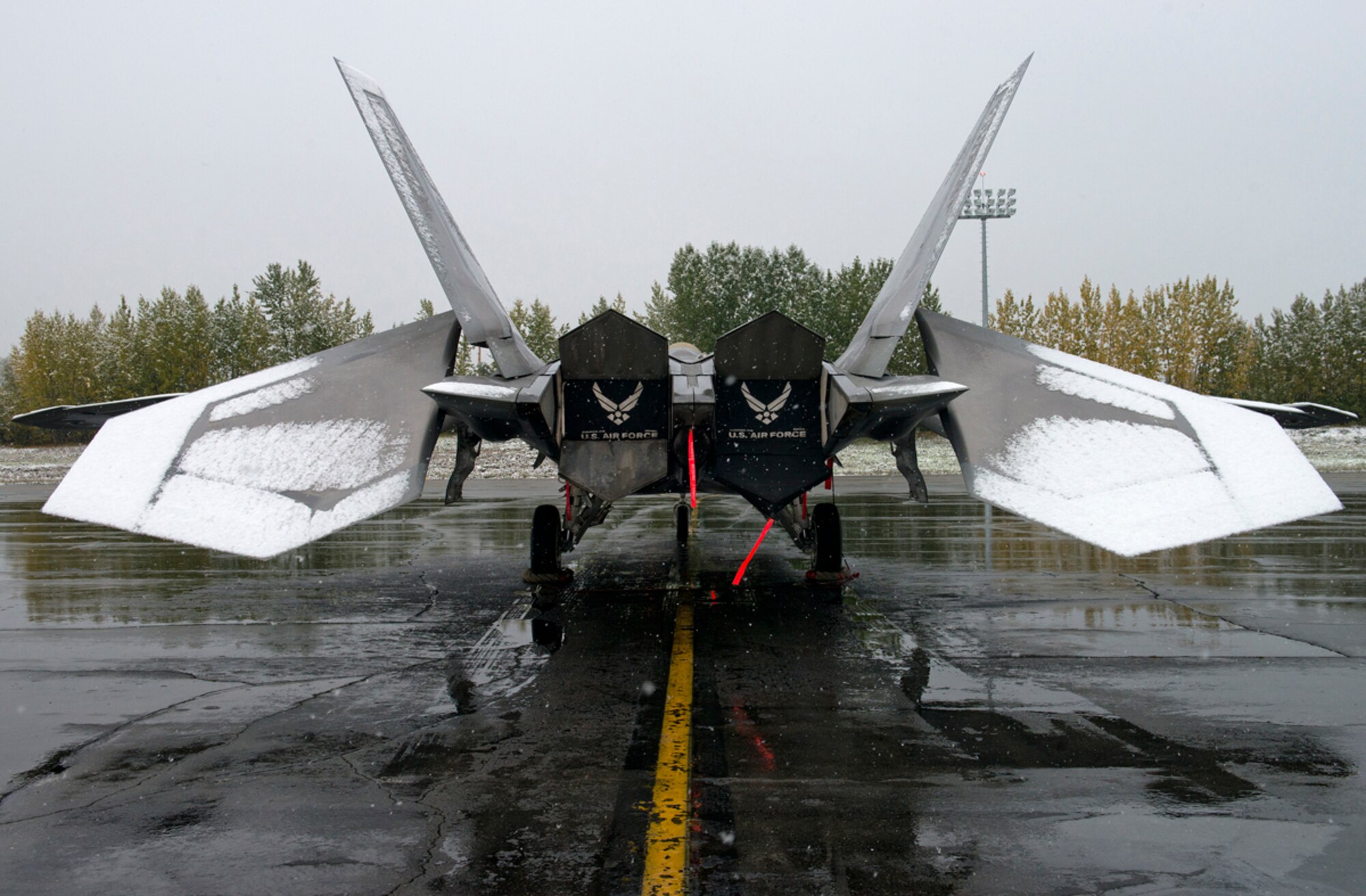 A F-22A Raptor sits on the flightline while snow falls on Joint Base Elmendorf-Richardson, Sept. 23, 2013. This was one of the earliest snowfalls in the Anchorage area in 20 years. (U.S. Air Force photo/Staff Sgt. Zachary Wolf)