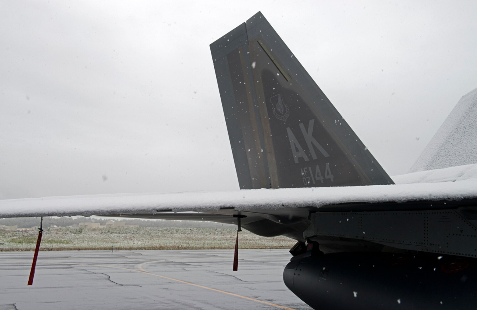 A F-22A Raptor sits on the flightline while snow falls on Joint Base Elmendorf-Richardson, Sept. 23, 2013. This was one of the earliest snowfalls in the Anchorage area in 20 years. (U.S. Air Force photo/Staff Sgt. Zachary Wolf)