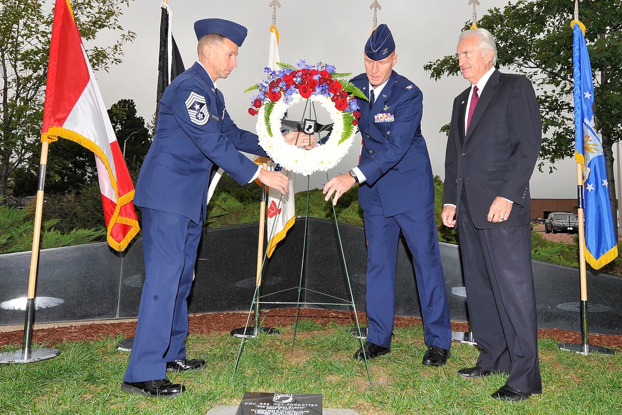 PETERSON AIR FORCE BASE, Colo. – Chief Master Sgt. Richard Redman (left) 21st Space Wing command chief, Col. Michael Hough, 21st SW vice commander, and retired Col. Paul Robinson, place a wreath at the Peterson POW/MIA memorial Sept. 20. Robinson was an Air Force pilot taken as a POW in Vietnam July 1, 1972, and was the guest speaker at the Peterson POW/MIA observance at the base chapel. Robinson was held POW for nine months at the Hanoi Hilton. (U.S. Air Force photo/Dennis Howk)
