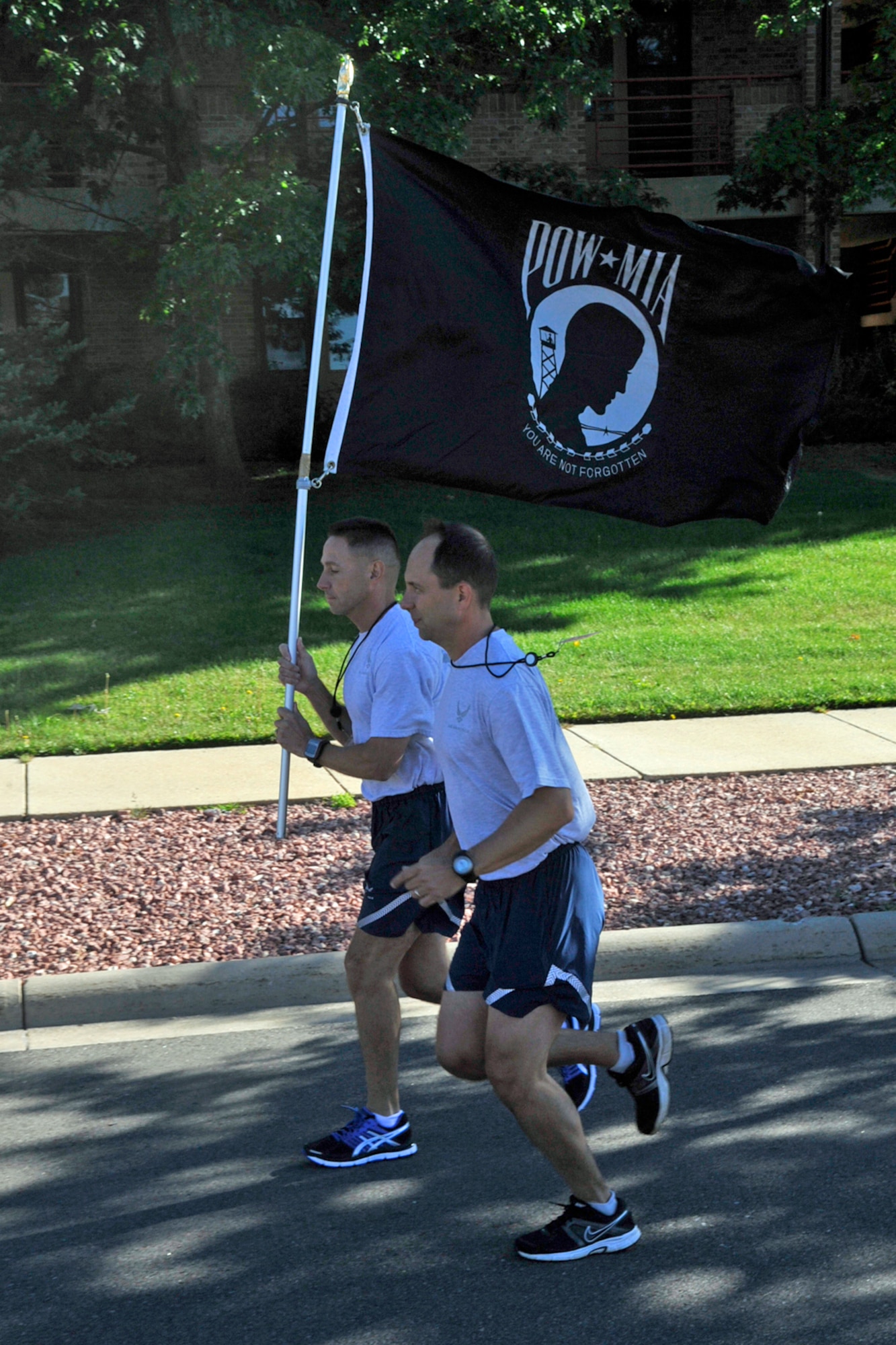 PETERSON AIR FORCE BASE, Colo. – Chief Master Sgt. Richard Redman (left), 21st Space Wing command chief, and Col. John Shaw, 21st Space Wing commander, carry the POW/MIA during the 24-hour run, part of POW/MIA week. The flag was the focal point of a 24-hour run, where teams carried it on a three-mile course around base. The 24-hour run culminated at 9 a.m. Sept. 20 when it arrived at the base chapel. (U.S. Air Force photo/Robb Lingley)