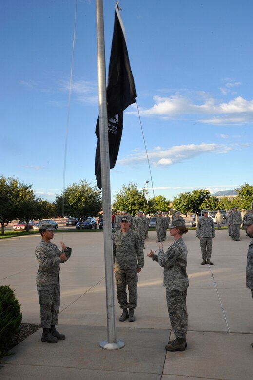 PETERSON AIR FORCE BASE, Colo. -- Airmen from the Vosler NCO Academy hold a reveille ceremony Sept. 18 at the Vosler NCO Academy. The ceremony marked the beginning of the Peterson POW/MIA week observance. Following a retreat ceremony Sept. 19, the flag was the focal point of a 24-hour run, where teams carried the flag on a three-mile course around base. The 24-hour run culminated at 9 a.m. Sept. 20 when it arrived at the base chapel for the base POW/MIA ceremony. (U.S. Air Force photo/Robb Lingley)