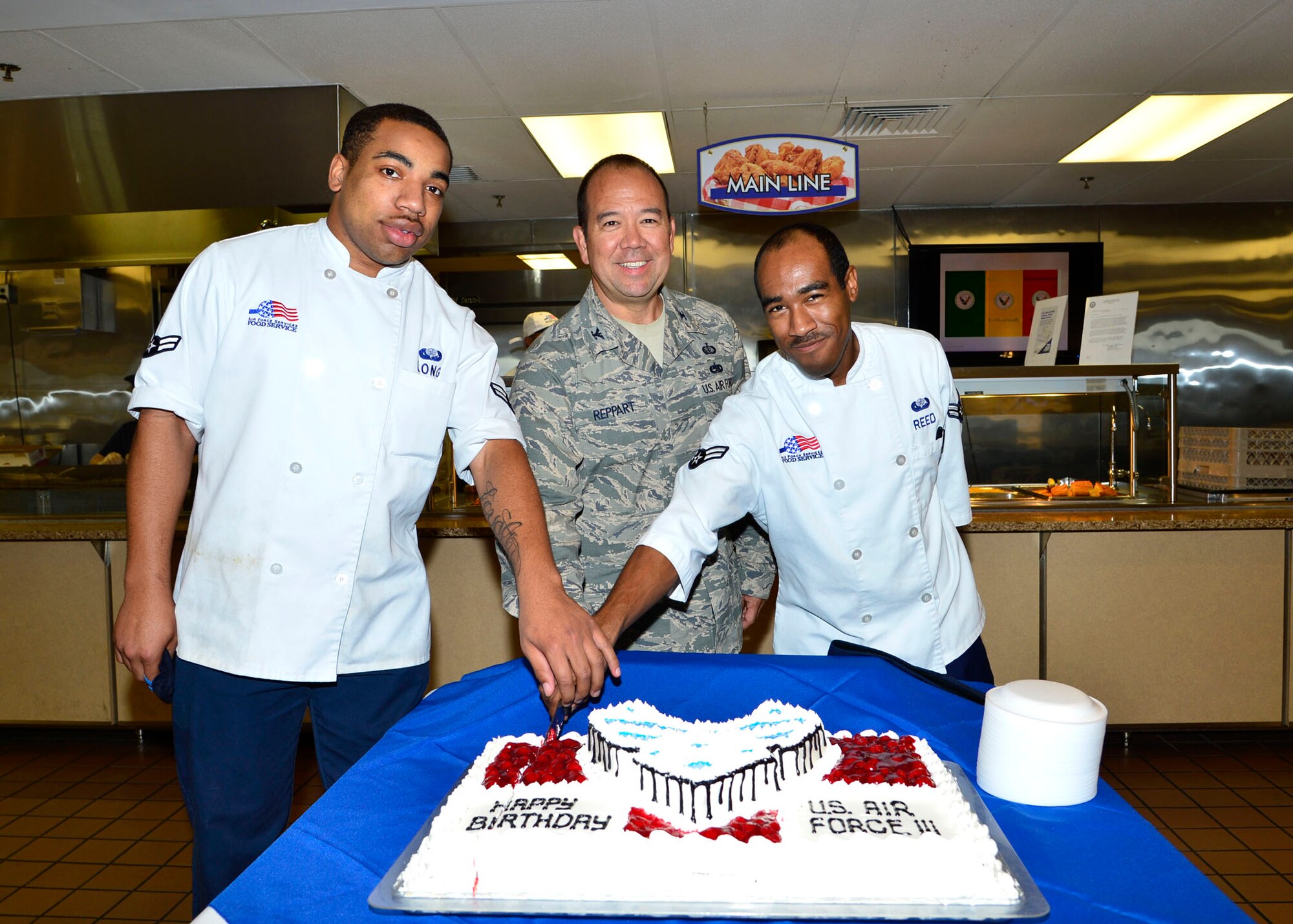 Col. Thomas Reppart, 436th Mission Support Group commander, cuts a cake along with Airman 1st Class Darrius Long, left, and Airman 1st Class Jerome Reed, right, both 436th Force Support Squadron food service technicians Sept. 18, 2013, at the Patterson Dining Facility on Dover Air Force Base, Del. The cake was made to celebrate the Air Force’s 66th birthday. (U.S. Air Force photo/David Tucker)