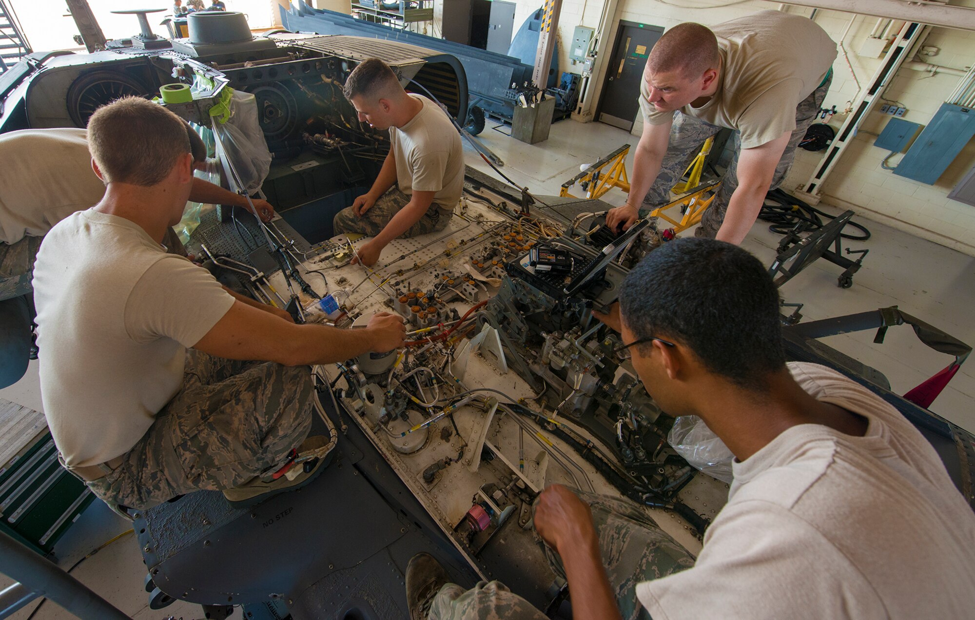 U.S. Air Force Airmen from the 723d Aircraft Maintenance Squadron install new hydraulic lines on top of an HH-60G Pave Hawk at Moody Air Force Base, Ga., Sept. 16, 2013. Installing hydraulic lines is part of on-the-job training many of the Airmen are completing with the help of more experienced maintainers. (U.S. Air Force photo by Airman 1st Class Ryan Callaghan/Released)

