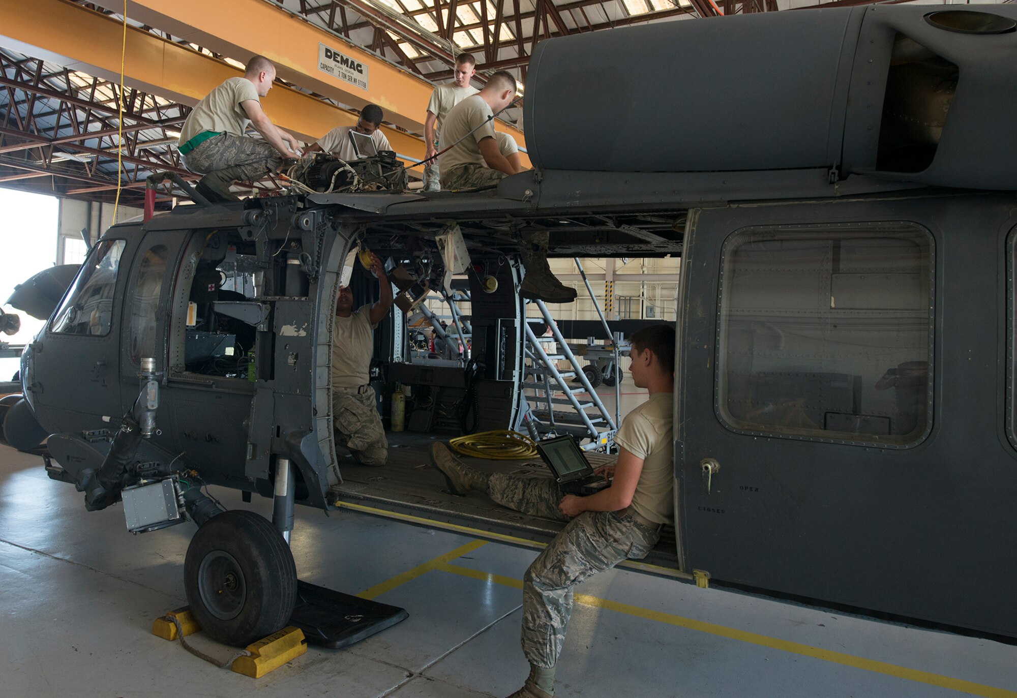 U.S. Air Force Airmen from the 723d Aircraft Maintenance Squadron consult technical orders while working on an HH-60G Pave Hawk at Moody Air Force Base, Ga., Sept. 16, 2013. The 723d AMXS maintainers returned this helicopter to mission-ready status after a transmission restoration. (U.S. Air Force photo by Airman 1st Class Ryan Callaghan/Released)
