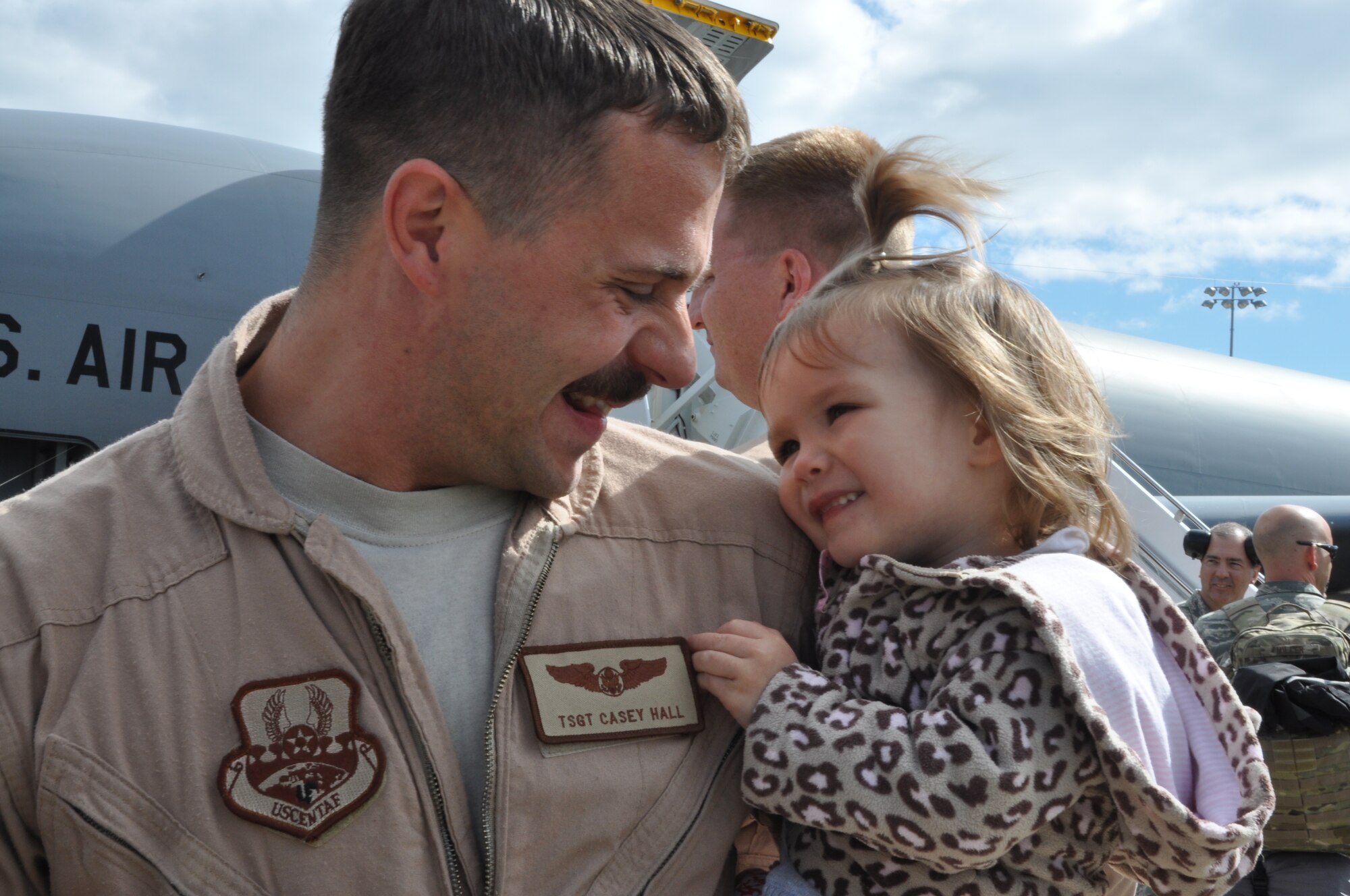 U.S. Air Force Tech. Sgt. Casey Hall, a boom operator for the 459th Air Refueling Wing at Joint Base Andrews, Md., smiles at his daughter as he returns from an overseas deployment, September 23, 2013. The troops were deployed to Southwest Asia in support of Operation Enduring Freedom. (U.S. Air Force photo/ Staff Sgt. Katie Spencer) 
