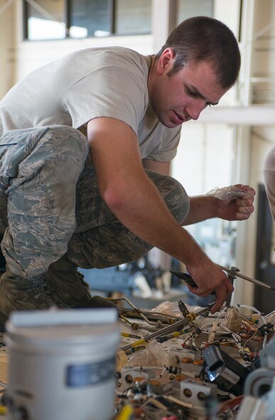 U.S. Air Force Senior Airman Lucas Stone, 723d Aircraft Maintenance Squadron crew chief, attaches new hydraulic lines on an HH-60G Pave Hawk at Moody Air Force Base, Ga., Sept. 16, 2013. New hydraulic lines were part of an estimated week-long rebuild to get the aircraft flight capable. (U.S. Air Force photo by Airman 1st Class Ryan Callaghan/Released)
