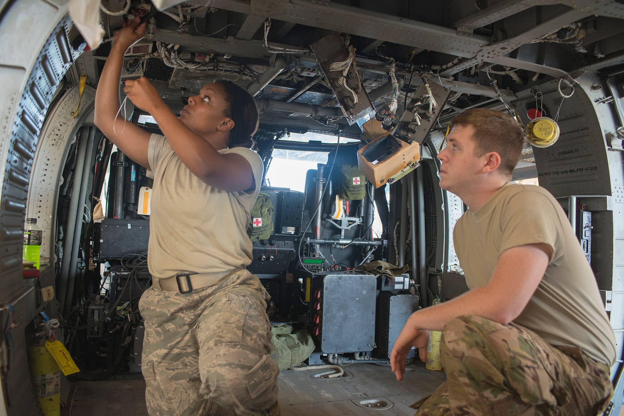 U.S. Air Force Senior Airman Jacquelyn Dismuke, left, 723d Aircraft Maintenance Squadron communication and navigation systems journeyman, and Airman 1st Class Marc Augst, 723d AMXS instrument and flight control journeyman, install lateral accelerometers into the cabin of an HH-60G Pave Hawk at Moody Air Force Base, Ga., Sept. 16, 2013. Aircraft maintainers follow step-by-step technical orders for any maintenance. (U.S. Air Force photo by Airman 1st Class Ryan Callaghan/Released)
