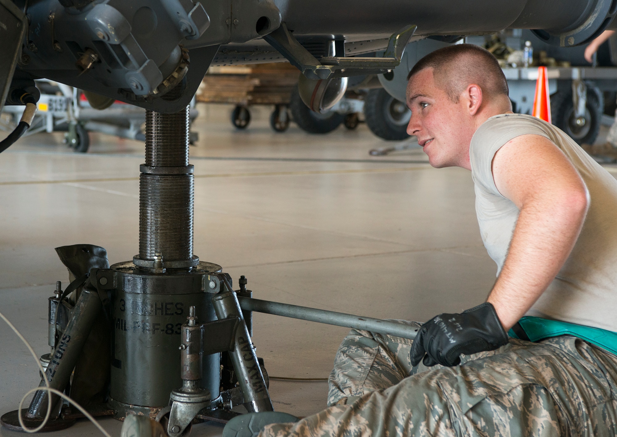 U.S. Air Force Senior Airman Joseph Roberts, 723d Aircraft Maintenance Squadron crew chief, uses a hand-powered hydraulic jack to lift an HH-60G Pave Hawk at Moody Air Force Base, Ga., Sept. 16, 2013. Maintainers must lift the helicopter and lower it onto wooden support cradles before any structural maintenance can be done. (U.S. Air Force photo by Airman 1st Class Ryan Callaghan/Released)
