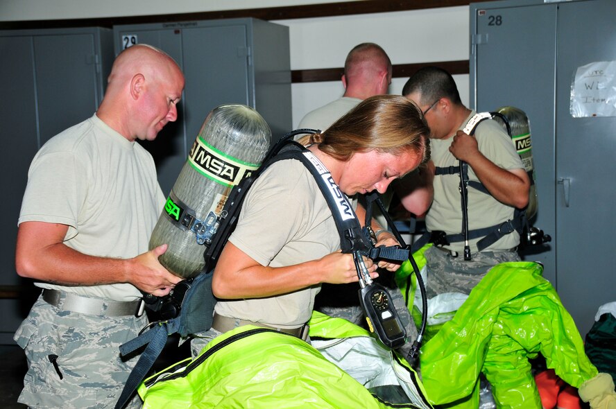 Tech. Sgt. Louis Cunningham adjusts the air tank on a Level A suit for Staff Sgt. Janel Miller during a a training exercise at Joint Base Pearl Harbor- Hickam, Hawaii August 03-17.  Both Tech. Sgt. Cunningham and Staff Sgt. Miller are Emergency Management personnel from McGhee Tyson ANG Base, TN.  (U.S. Air National Guard photo by Master Sgt. Kendra M Owenby/Released)