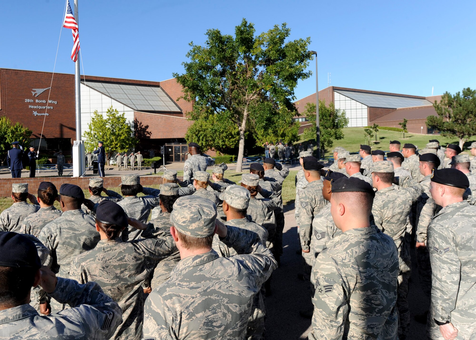 Airmen render salutes as the U.S. flag is raised to full staff then lowered during the POW/MIA retreat ceremony in front of the 28th Bomb Wing Headquarters building at Ellsworth Air Force Base, S.D., Sept. 20, 2013. The ceremony honored servicemembers listed as missing in action or served as a prisoner of war – recognizing the sacrifices they’ve made for their country. (U.S. Air Force photo by Airman 1st Class Anania Tekurio/Released) 