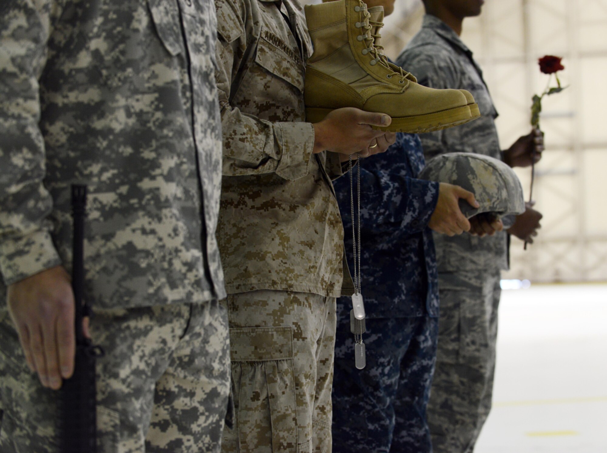 Military members each carry items used to assemble the fallen warrior battle cross during the POW/MIA recognition day ceremony at Hangar 1 Sept. 20. There are 1,644 American personnel listed by the Defense Department?s POW/MIA office as missing and unaccounted for since the Vietnam War as of Sept. 13, 2013. (U.S. Air Force photo/Airman Ty-Rico Lea)