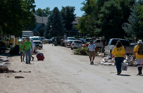 Columbia Drive in Longmont, Colo., is crowded Sept. 21, 2013, with relief workers, piles of debris and vehicles as the neighborhood starts the long healing process after being ravaged by floodwaters. F.E. Warren Air Force Base Airmen joined the army of volunteers digging out basements, pulling up tile and hauling wet installation to the curb to be picked up by the city. (U.S. Air Force photo by R.J. Oriez)