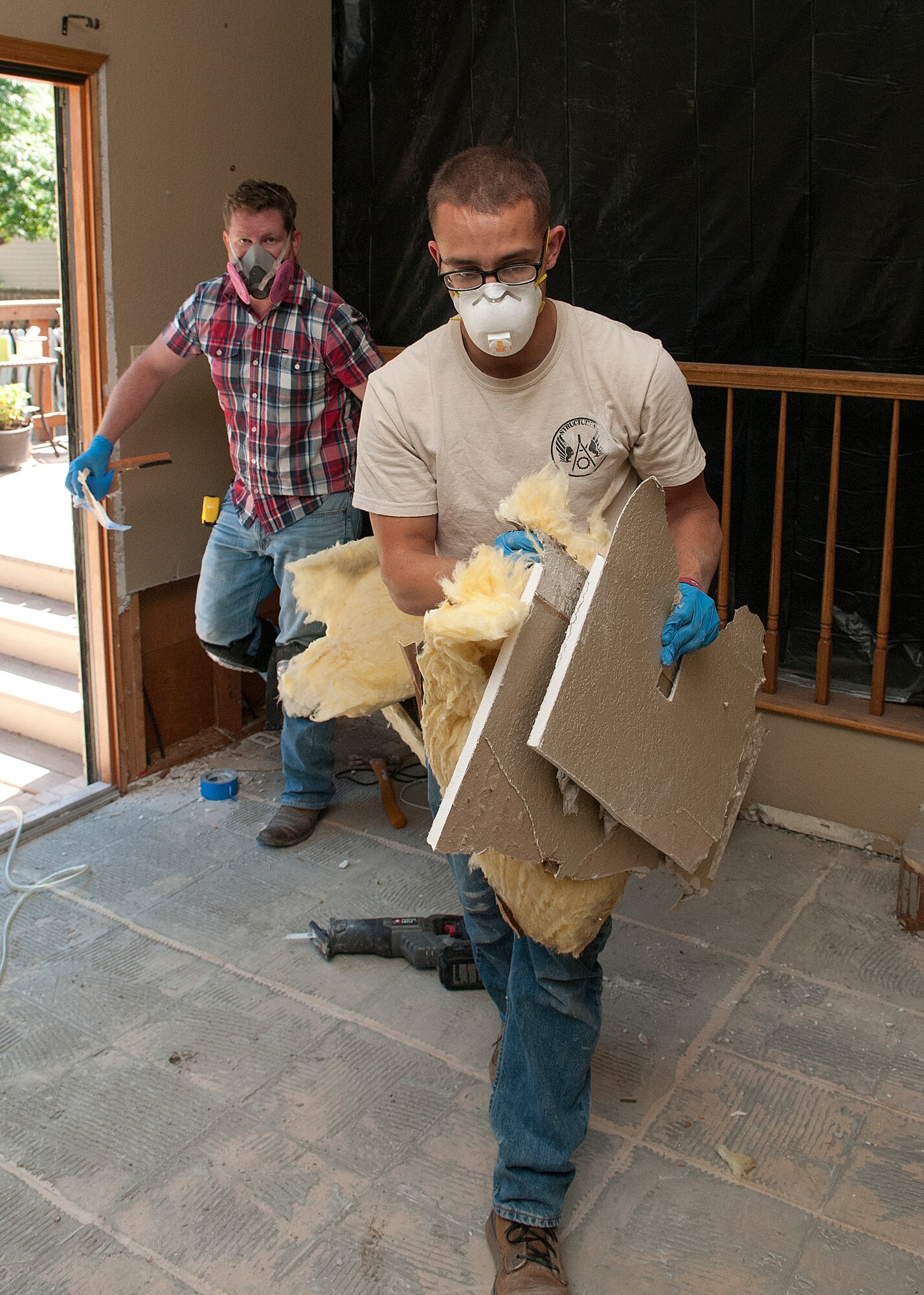 Airman 1st Class Donald Neal, 90th Civil Engineer Squadron structure shop, helps carry damaged plaster board and installation from Deedra Moats’ home in Longmont, Colo., Sept. 21, 2013. Neal helped Jamie McVaney, a mold mitigation expert, work to minimize the damage to the residence after it was swamped by flood waters. Neal was one of several F.E. Warren Air Force Base, Wyo., Airmen who volunteered in relief efforts for the flood-ravaged northern Colorado town. (U.S. Air Force photo by R.J. Oriez)