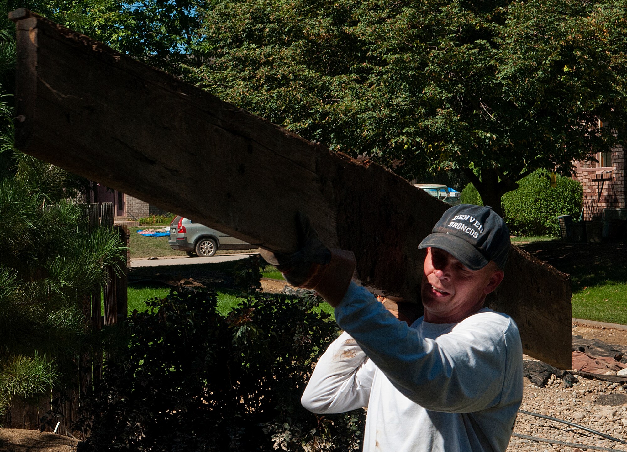 Maj. Darrel Johnson, 90th Missile Wing command post director, carries part of a demolished fence to a curbside rubbish pile in Longmont, Colo., Sept. 21, 2013. Johnson led a volunteer team of F.E. Warren Air Force Base, Wyo., Airmen in relief efforts for the flood-ravaged northern Colorado town. (U.S. Air Force photo by R.J. Oriez)
