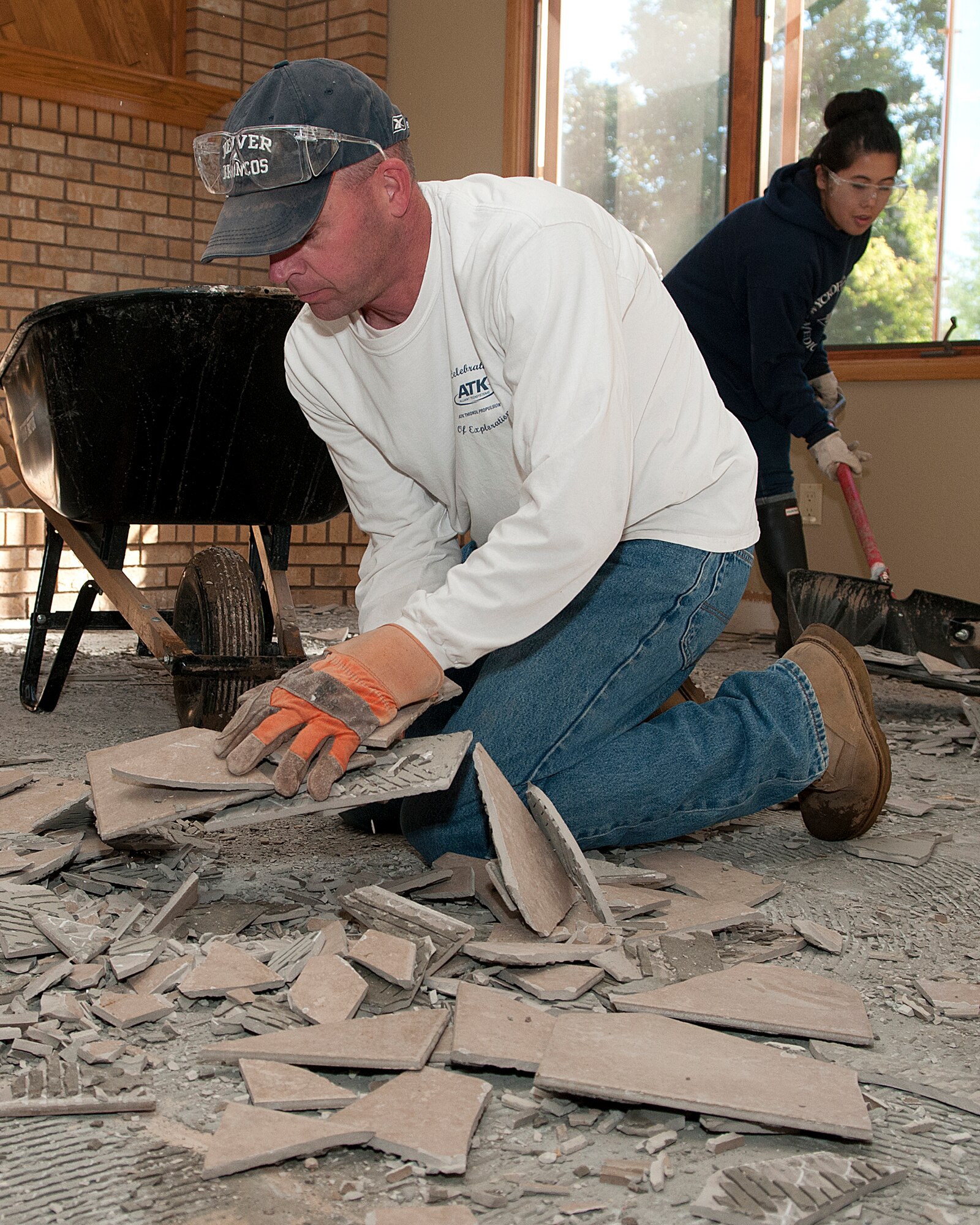 Maj. Darrel Johnson, 90th Missile Wing command post director, and Senior Airman Julielyn Lew, 90th Comptroller Squadron, remove tile from a flood-damaged Longmont, Colo., home Sept. 21, 2013. Johnson led a volunteer team of F.E. Warren Air Force Base, Wyo., Airmen in relief efforts for the flood-ravaged Northern Colorado town. (U.S. Air Force photo by R.J. Oriez)