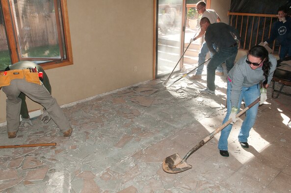 Senior Airman Emily McDonald, 90th Missile Wing command post, joins other volunteers from F.E. Warren Air Force Base, Wyo., in tearing up tile in a flood-damaged Longmont, Colo., home Sept. 21 2013. A group of 90th MW Airmen volunteered to help some of the victims of the floods the ravaged parts of Northern Colorado earlier in the month. (U.S. Air Force photo by R.J. Oriez)