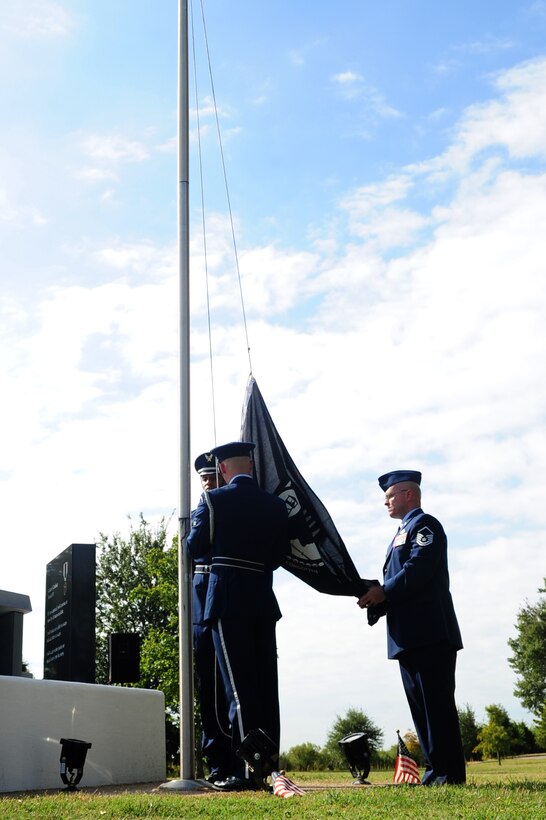 U.S. Air Force Master Sgt. Jeffrey Koenig,  Air Force Sergeants Association Chapter 358 president, helps members of the Langley Air Force Base Honor Guard raise the POW/MIA flag over the POW/MIA Memorial at Langley Air Force Base, Va.,  Sept. 20, 2013. Volunteer runners kept the flag in constant motion for during a 24-hour run in honor of POW/MIA Service members. (U.S. Air Force photo by Airman Areca T. Wilson/Released)
