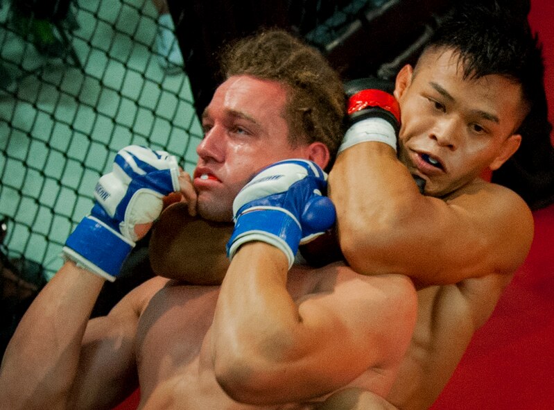 Kit Vongprachanh tightens his choke hold on John Cobb during the first round of their fight at Strike Fight II Sept. 21 at Eglin Air Force Base, Fla.  Cobb tapped out a few seconds later giving Vongprachanh the victory.  This was Eglin’s second mixed martial arts event.  (U.S. Air Force photo/Samuel King Jr.)