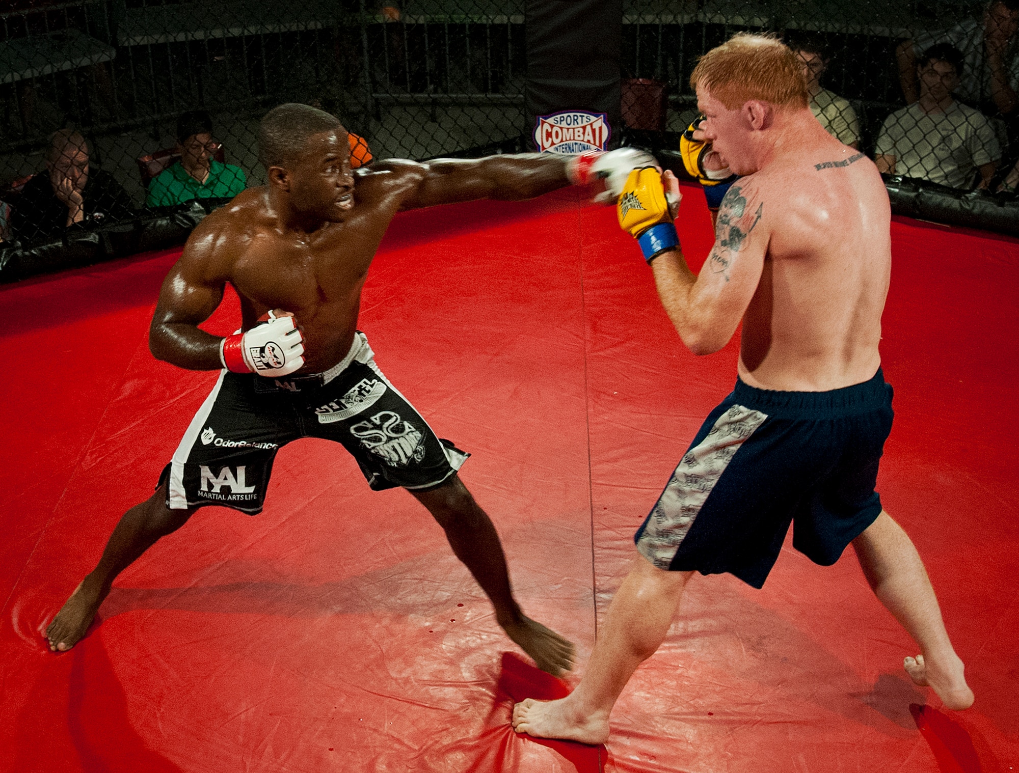 Steve Burks delivers a jab to Mark Deford during the main event of Strike Fight II Sept. 21 at Eglin Air Force Base, Fla.  Burks won the fight with a technical knockout in the third round.  Burks is an active-duty Air Force recruiter in Crestview, Fla.  This was Eglin’s second mixed martial arts event.  (U.S. Air Force photo/Samuel King Jr.)