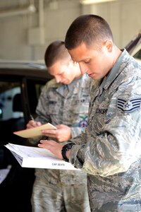 U.S. Air Force Staff Sgt. Marc Proctor, 633rd Civil Engineer Squadron crew chief, assists Airman 1st Class Jeremy Burnett, 633rd CES firefighter while checking a car seat during the child safety seat inspection day at Langley Air Force Base, Va., Sept. 14, 2013. The installers are members of the Joint Base Langley-Eustis fire departments who have been certified by the Virginia Department of Health, and are able to install and inform on more than 40 different types of car seats. (U.S. Air Force photo by Airman 1st Class Kimberly Nagle/Released)