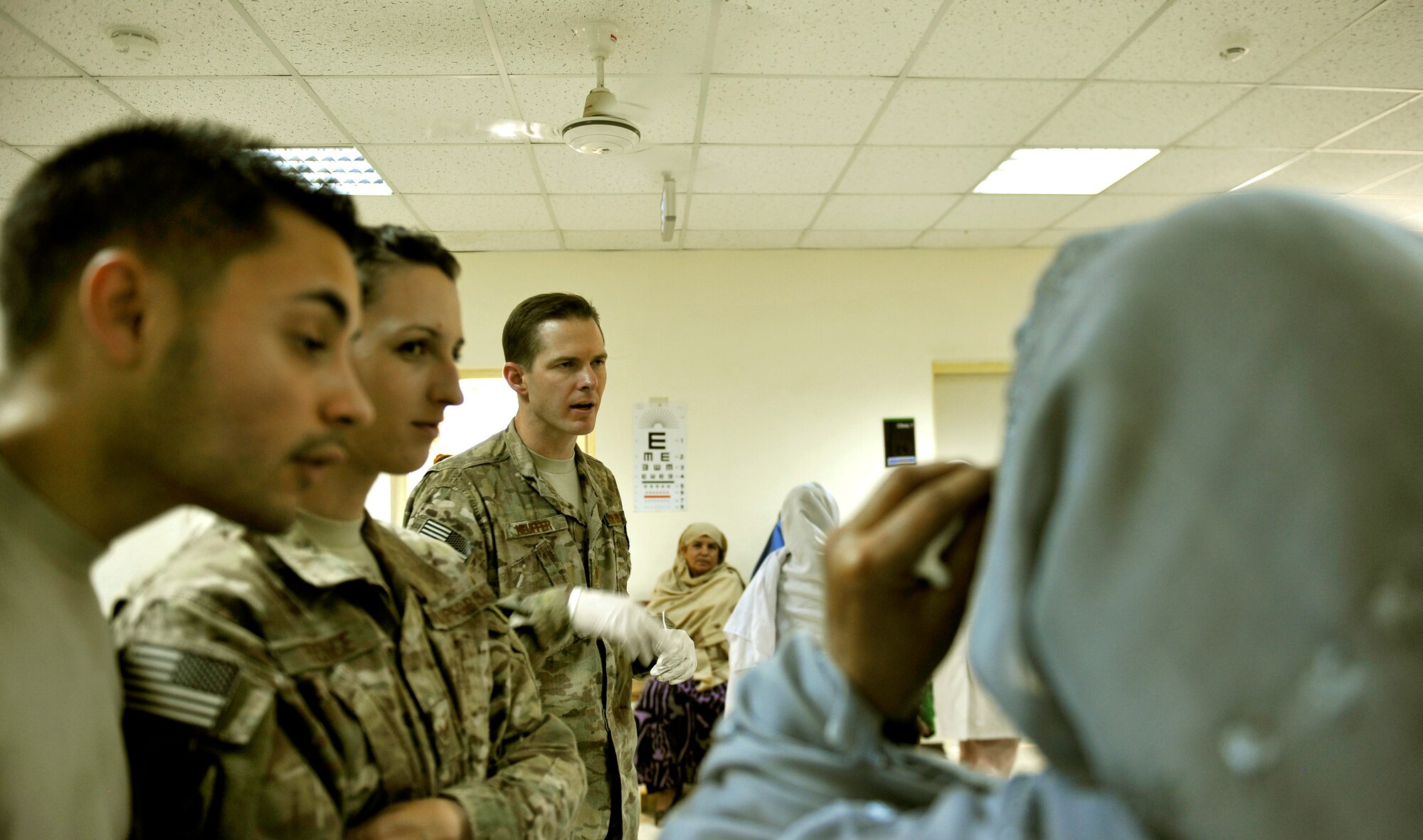 Maj. Marcus Neuffer, 455th Expeditionary Medical Group ophthalmologist, conducts an eye exam on an Afghan patient after giving her prescription glasses in the Korean Hospital on Bagram Air Field, Afghanistan, Sept. 18. Five months ago after arriving on Bagram, he established a program to provide glasses to Afghan and coalition members in need. The glasses come from former patients and non-profits. This is the second time they have held an eye glasses clinic here. He is deployed from Keesler Air Force Base, Miss. (U.S. Air Force photo/ Staff Sgt. Stephenie Wade)

