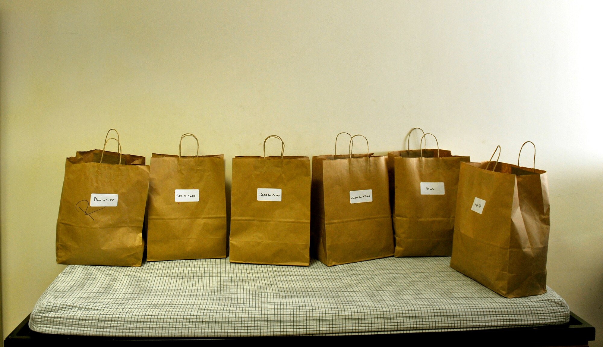 Five months ago after arriving on Bagram, Maj. Marcus Neuffer 455th Expeditionary Medical Group ophthalmologist, established a program to provide glasses to Afghan and coalition members in need. The glasses that fill these bags come from former patients and non-profits. This is the second time they have held an eye glasses clinic here. He is deployed from Keesler Air Force Base, Miss. (U.S. Air Force photo/ Staff Sgt. Stephenie Wade)

