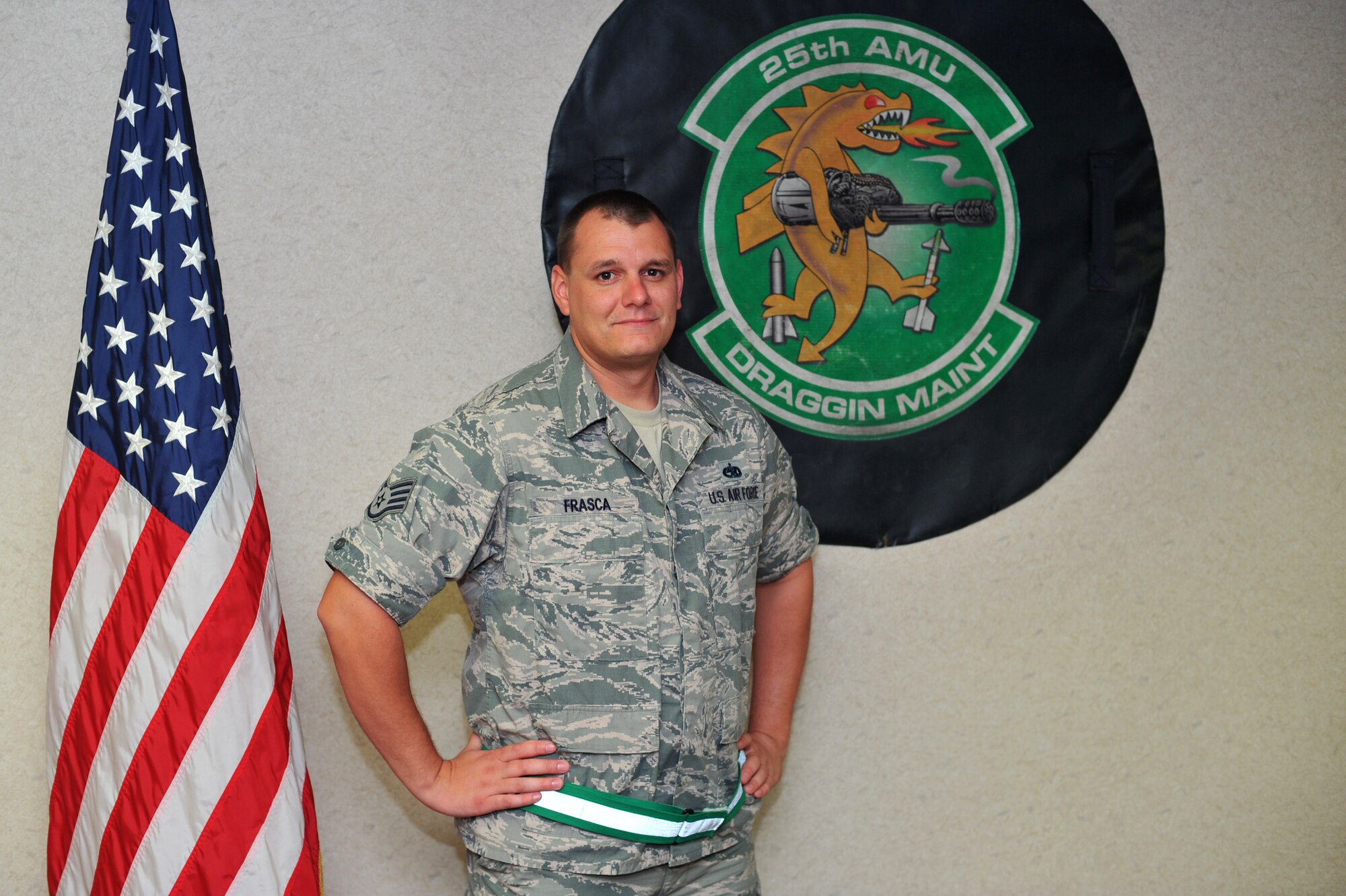 Staff Sgt. Kenneth Frasca, 25th Aircraft Maintenance Unit building NCO in charge, ration monitor, information assurance officer and record custodian, poses in front of the 25th AMU's symbol at Osan Air Base, Republic of Korea, Sept. 11, 2013. Frasca is this week’s Airman Spotlight winner. (U.S. Air Force photo/Staff Sgt. Emerson Nuñez)

