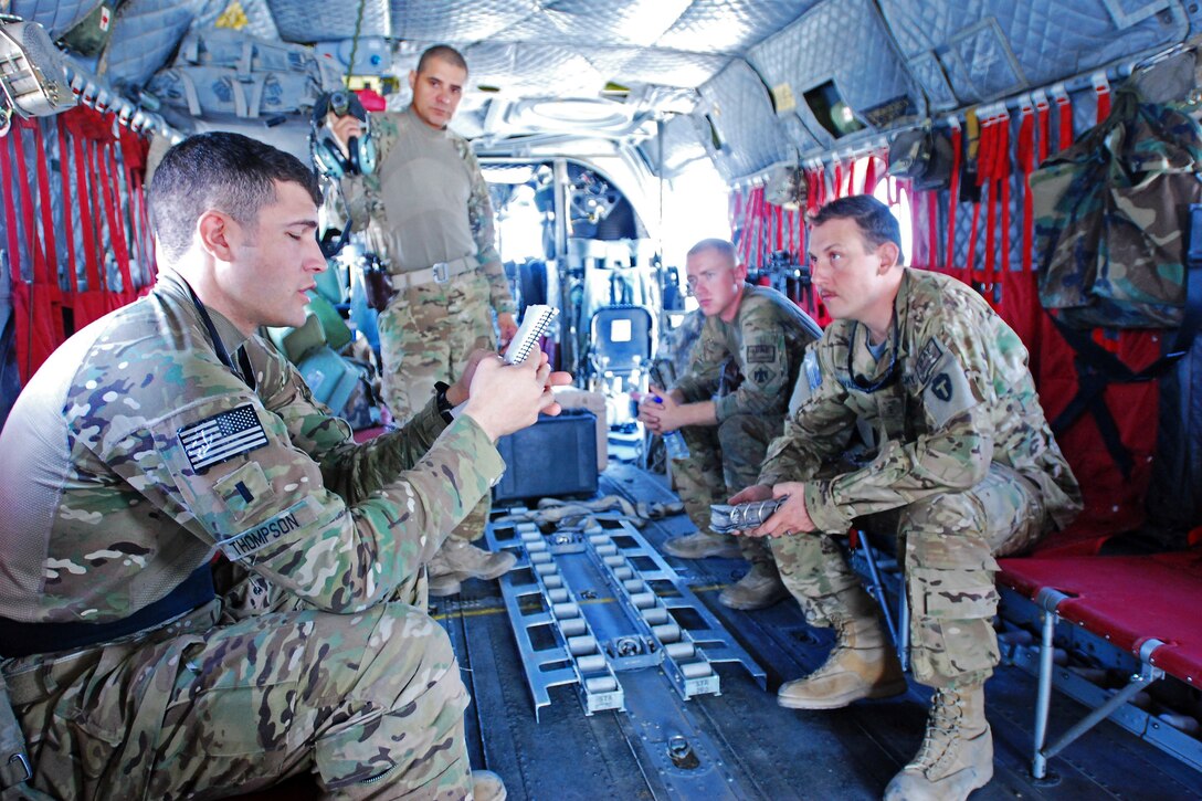 U.S. Army 1st Lt. Jared Thompson, foreground, briefs U.S. Army Staff Sgt. Ignacio Lopez, back left, U.S. Army Pfc. Zach Fike, back right, and U.S. Army Chief Warrant Officer 3 Andre Lavallee, right, before a personnel and equipment movement mission on Bagram Airfield, Afghanistan, Sept. 22, 2013. Thompson and Lavallee, pilots, and Lopez and Fike, crew chiefs, are assigned to the Texas-Oklahoma National Guard's Company B, 2nd Battalion General Support, 149th Aviation Regiment, which is attached to the 10th Combat Aviation Brigade.