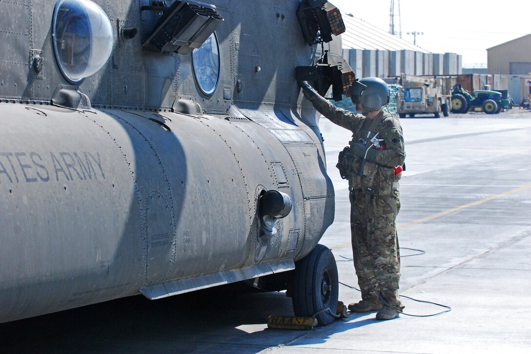 U.S. Army Sgt. Dan Glenn inspects the auxiliary power unit fuel shut-off switch on a CH-47 Chinook helicopter during start-up procedures before a personnel and equipment movement mission on Bagram Airfield, Afghanistan, Sept. 22, 2013. Glenn, a crew chief, is assigned to the Texas-Oklahoma National Guard's Company B, 2nd Battalion General Support, 149th Aviation Regiment, which is attached to the 10th Combat Aviation Brigade.